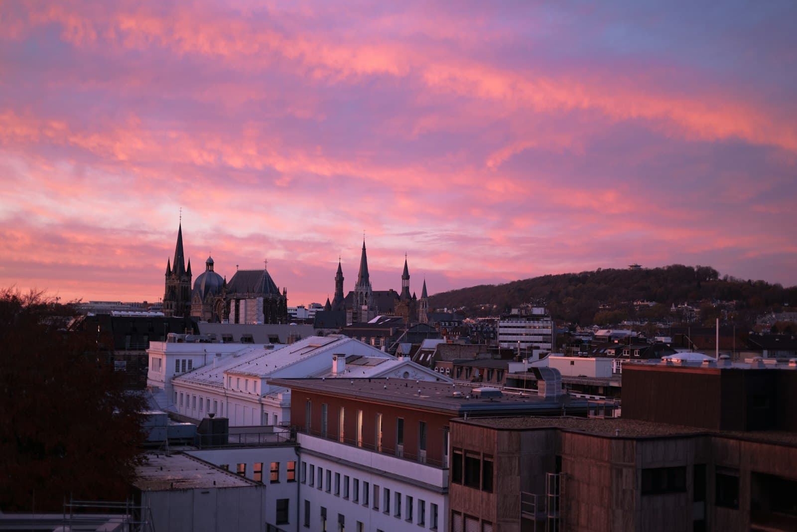 Aachen — a view of a city at sunset with a pink sky