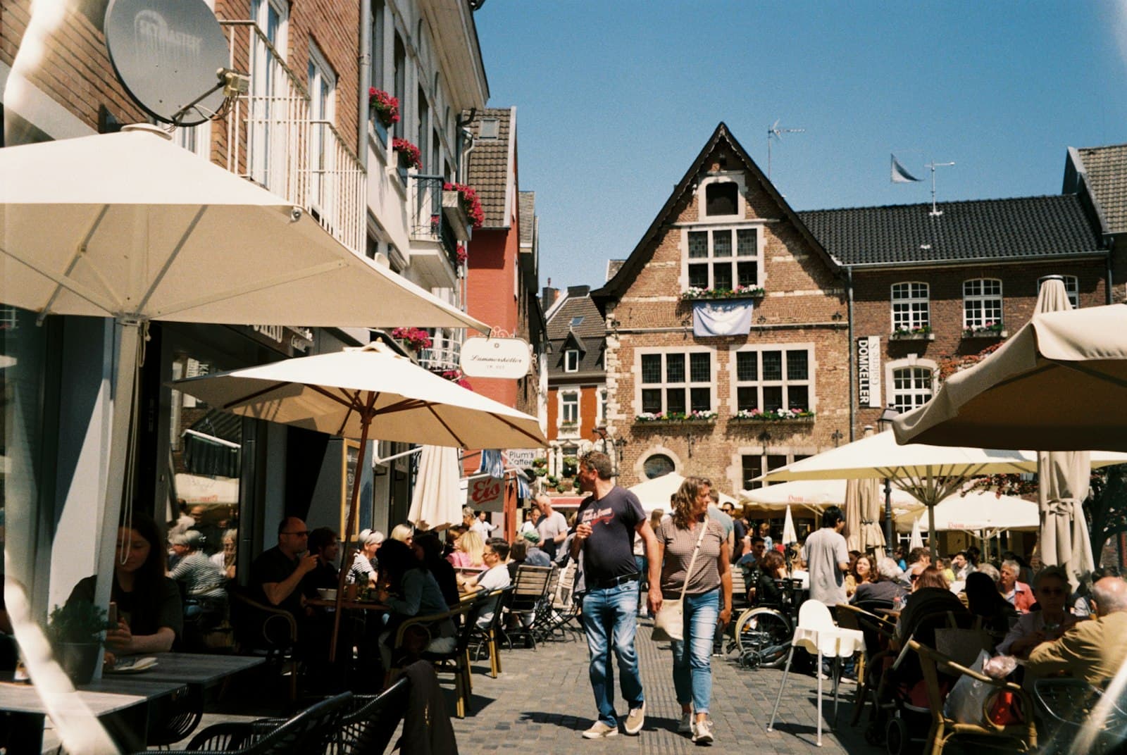 Aachen — a group of people sitting at tables outside of a building