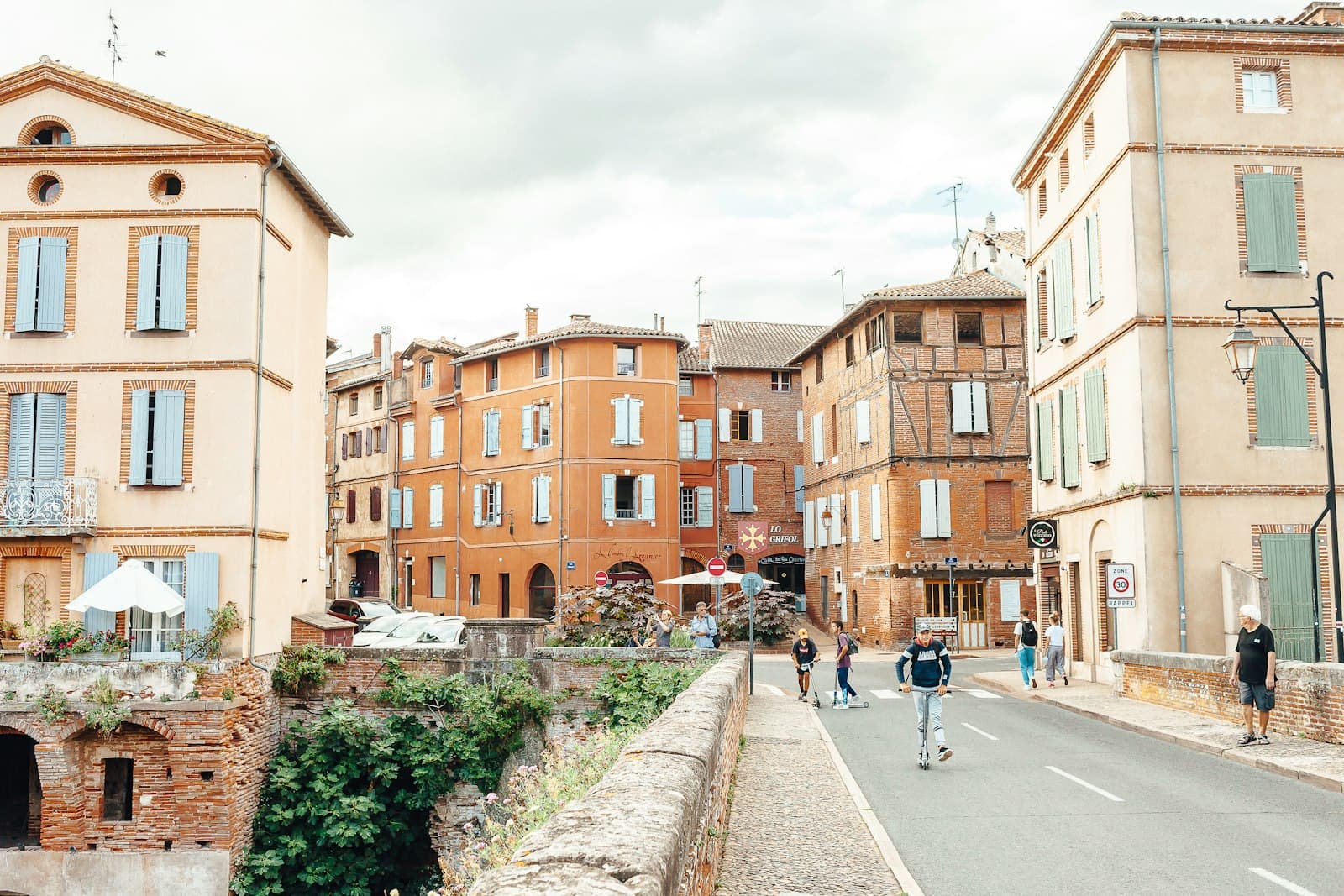 Albi — a group of people walking down a street next to tall buildings