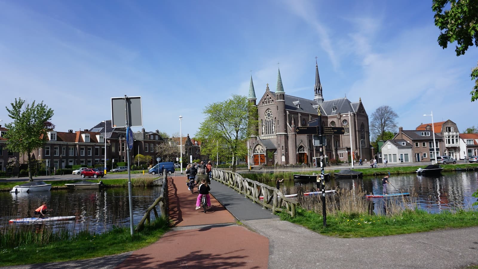 Alkmaar — a group of people walking down a sidewalk next to a river