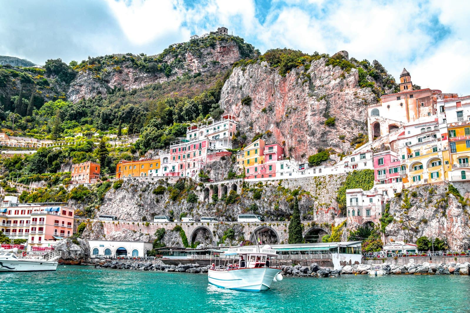 Amalfi — white boat on body of water near green and brown mountain during daytime