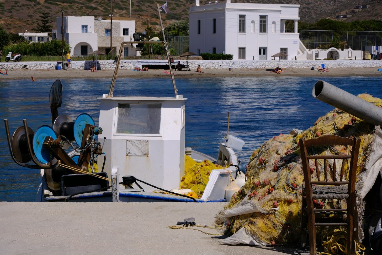 Amorgos — A chair sitting on the side of a body of water