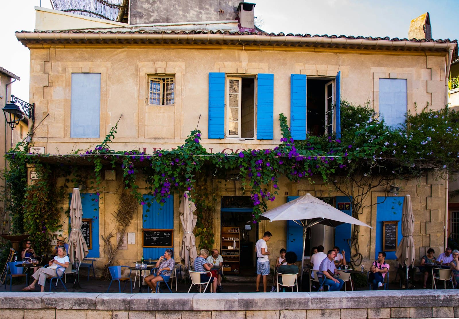 Arles — a group of people sitting outside of a building