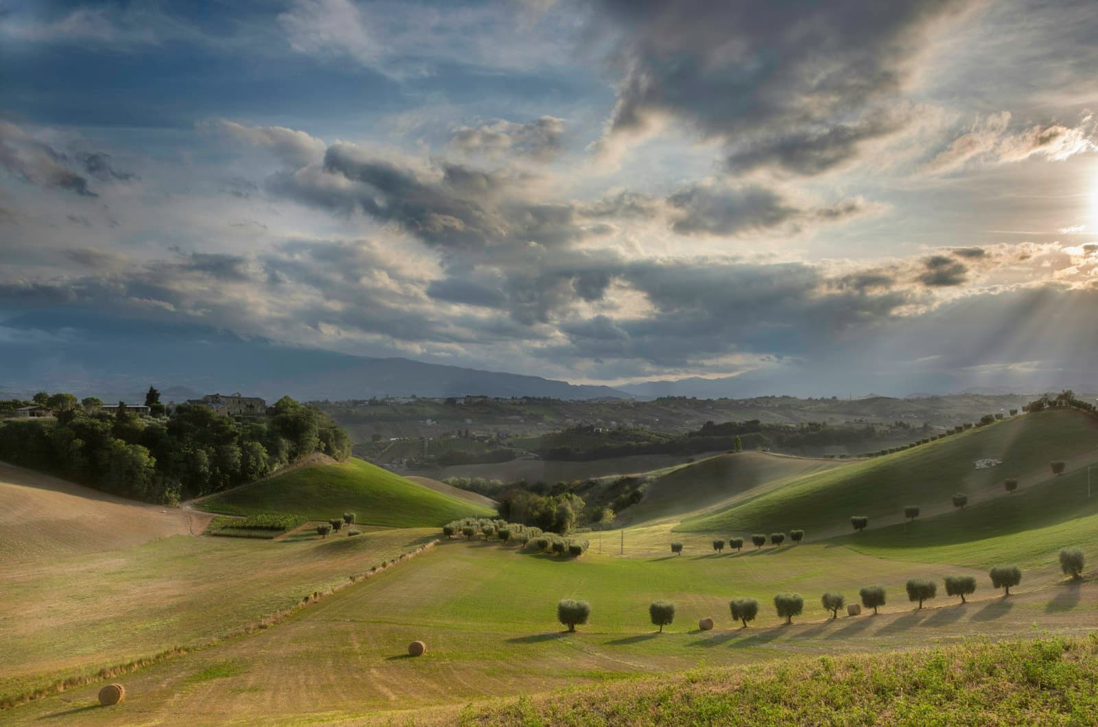 Ascoli Piceno — the sun shines through the clouds over rolling hills