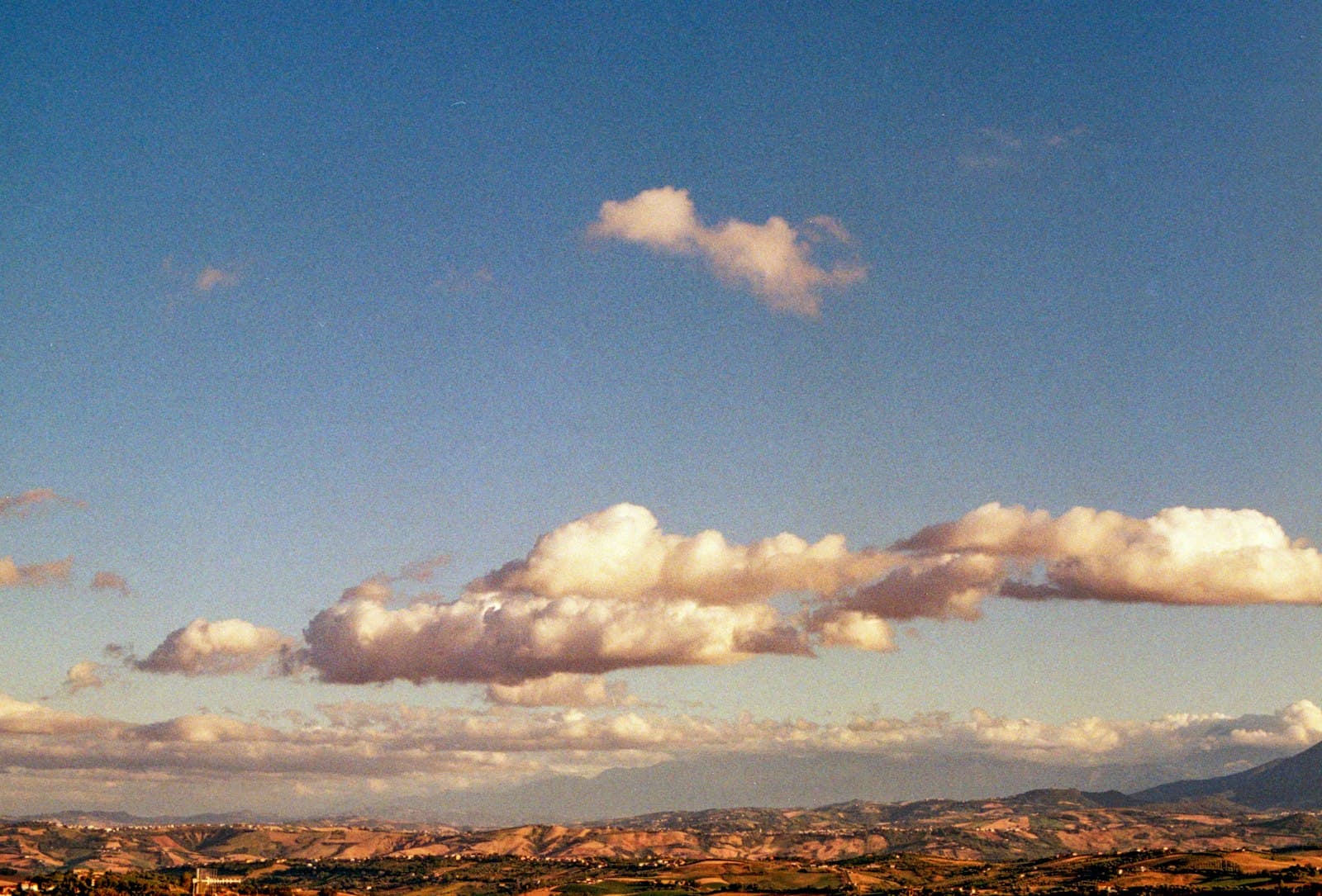 Ascoli Piceno — Fluffy clouds drift across a clear blue sky.