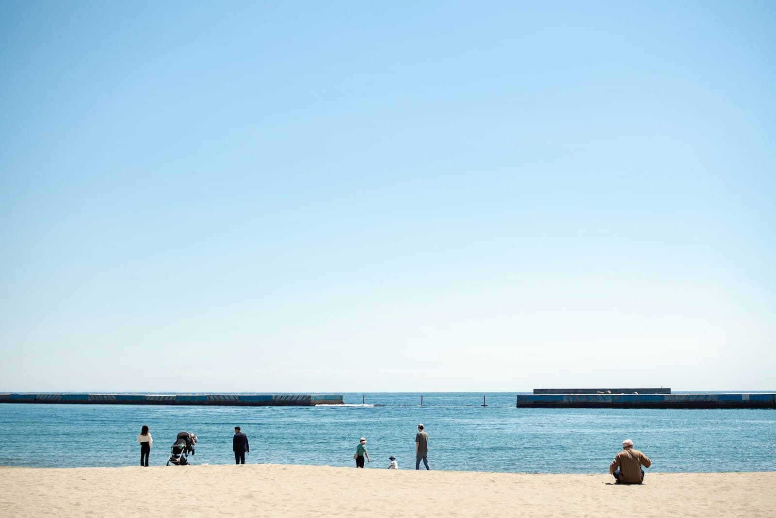 Atami — a group of people standing on top of a sandy beach