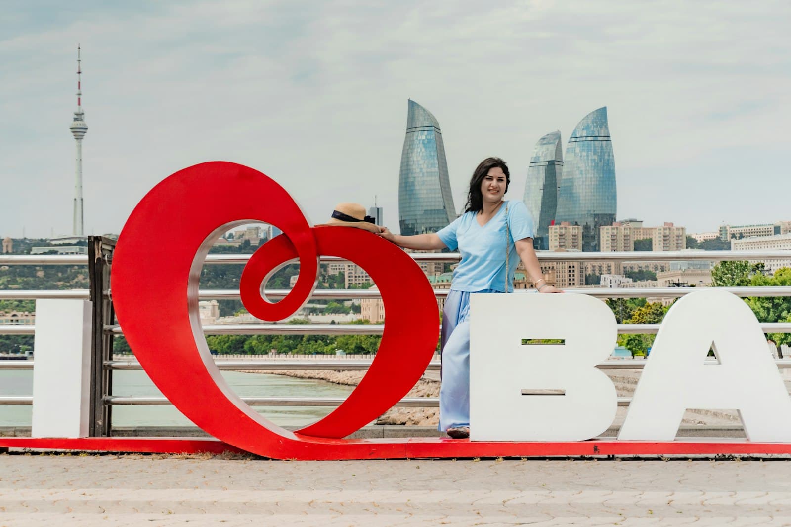 Baalbek — Woman poses with 'i love ba' sign and city skyline.