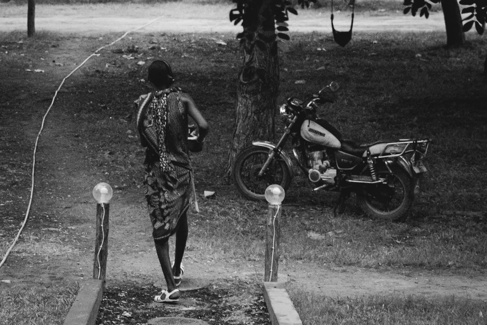 Bagamoyo — a man walking towards a motorcycle parked on the side of a road