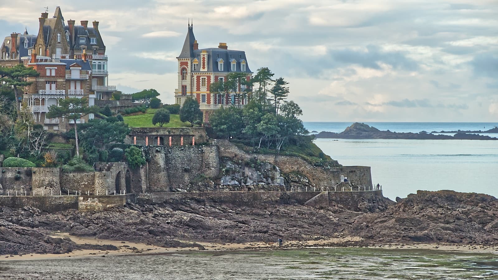 Béhuard — brown and white concrete building on cliff near body of water during daytime