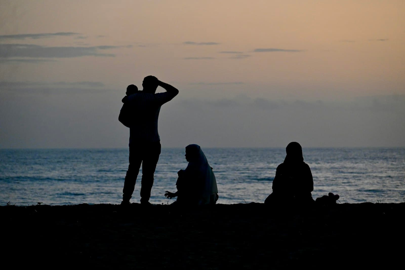 Bekal — A group of people standing on top of a beach next to the ocean