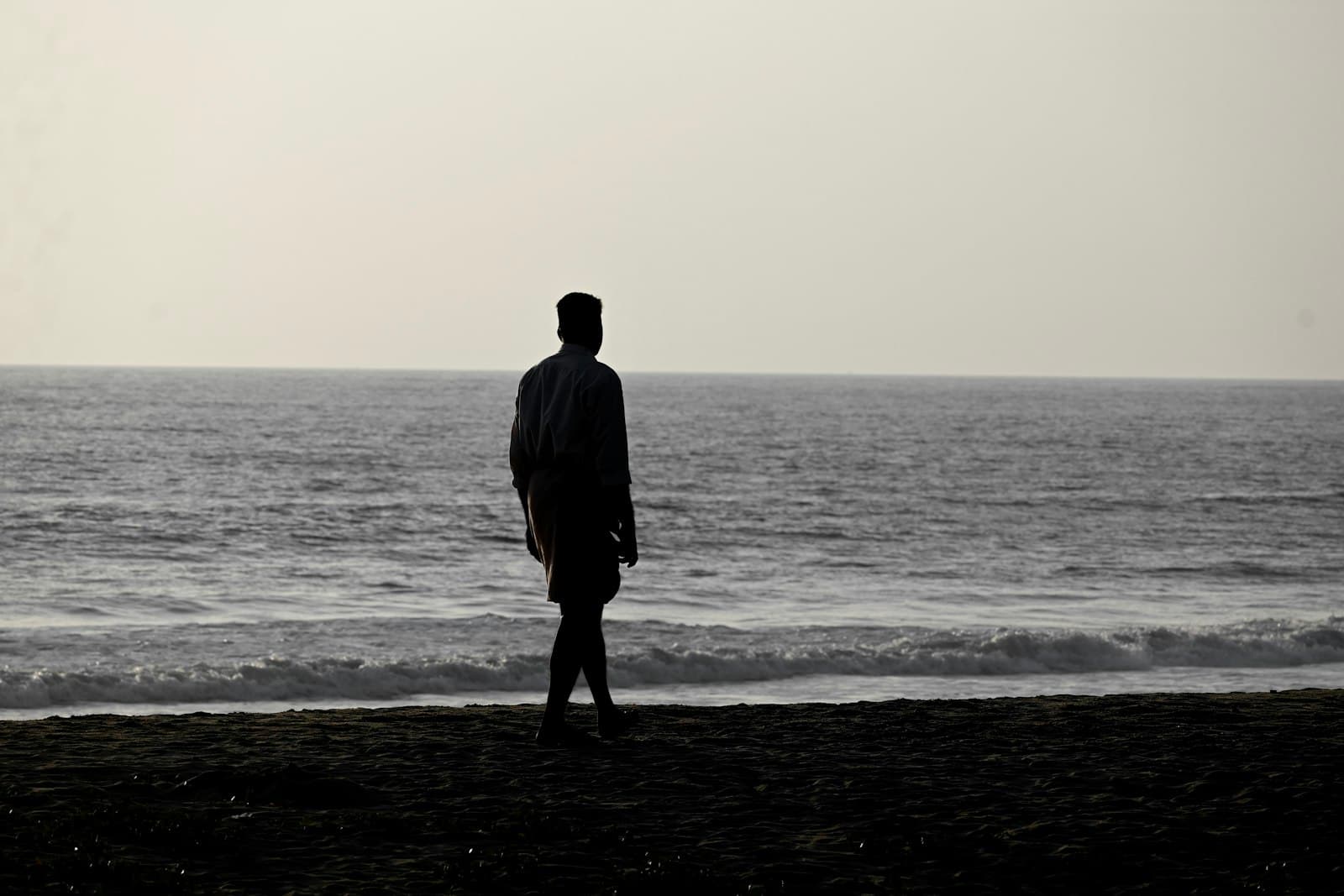 Bekal — A man standing on a beach next to the ocean