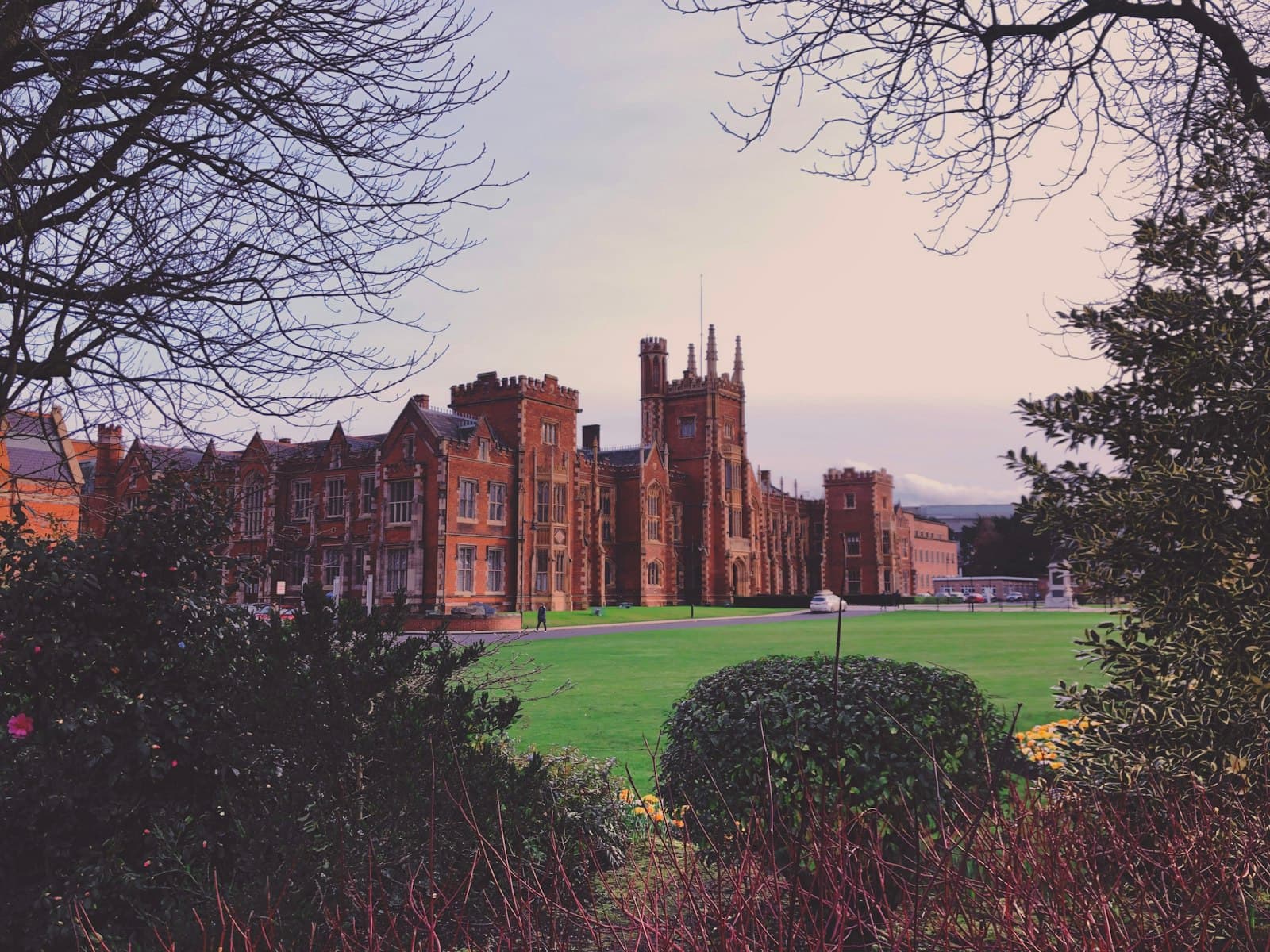 Belfast — a large building sitting next to a lush green field