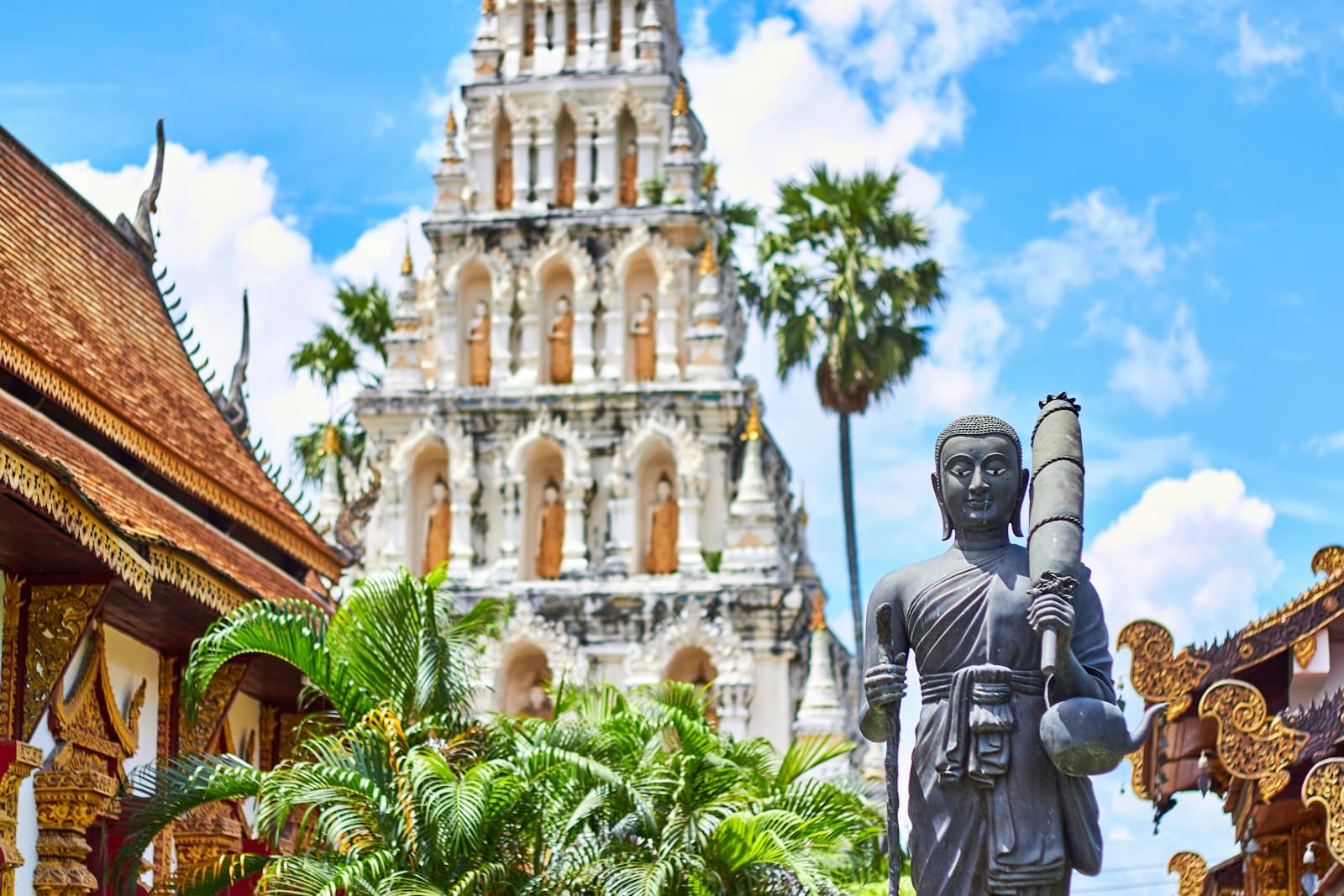 Betong — religious figurine near gray concrete mosque under blue and white cloudy sky