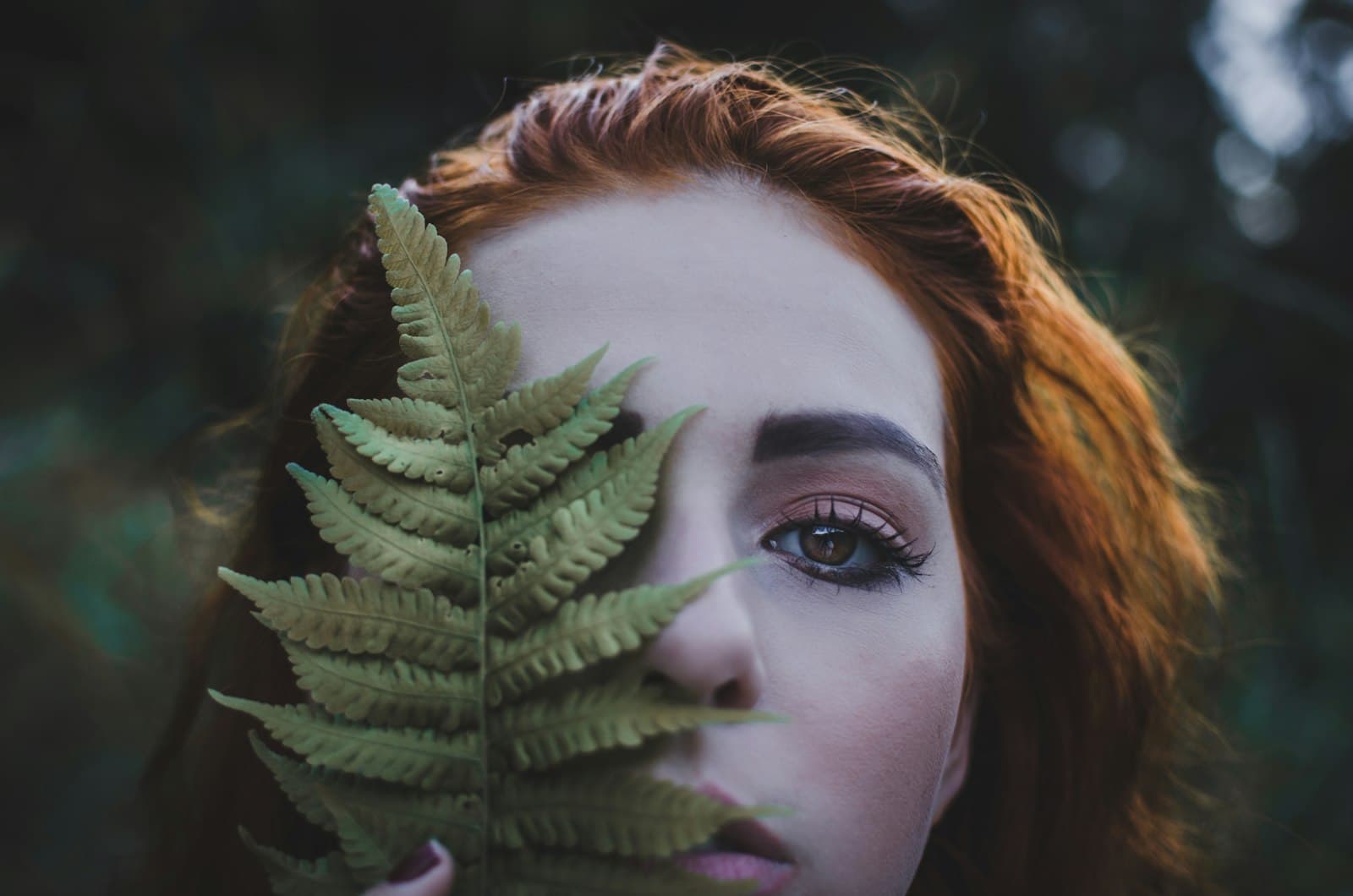 Blumenau — woman holding a green leaf at daytime