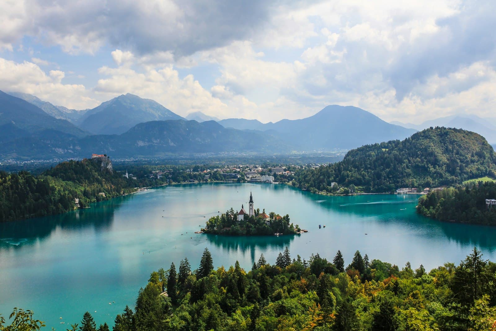 Bohinj — high-angle photography of white building surrounded by body of water at daytime