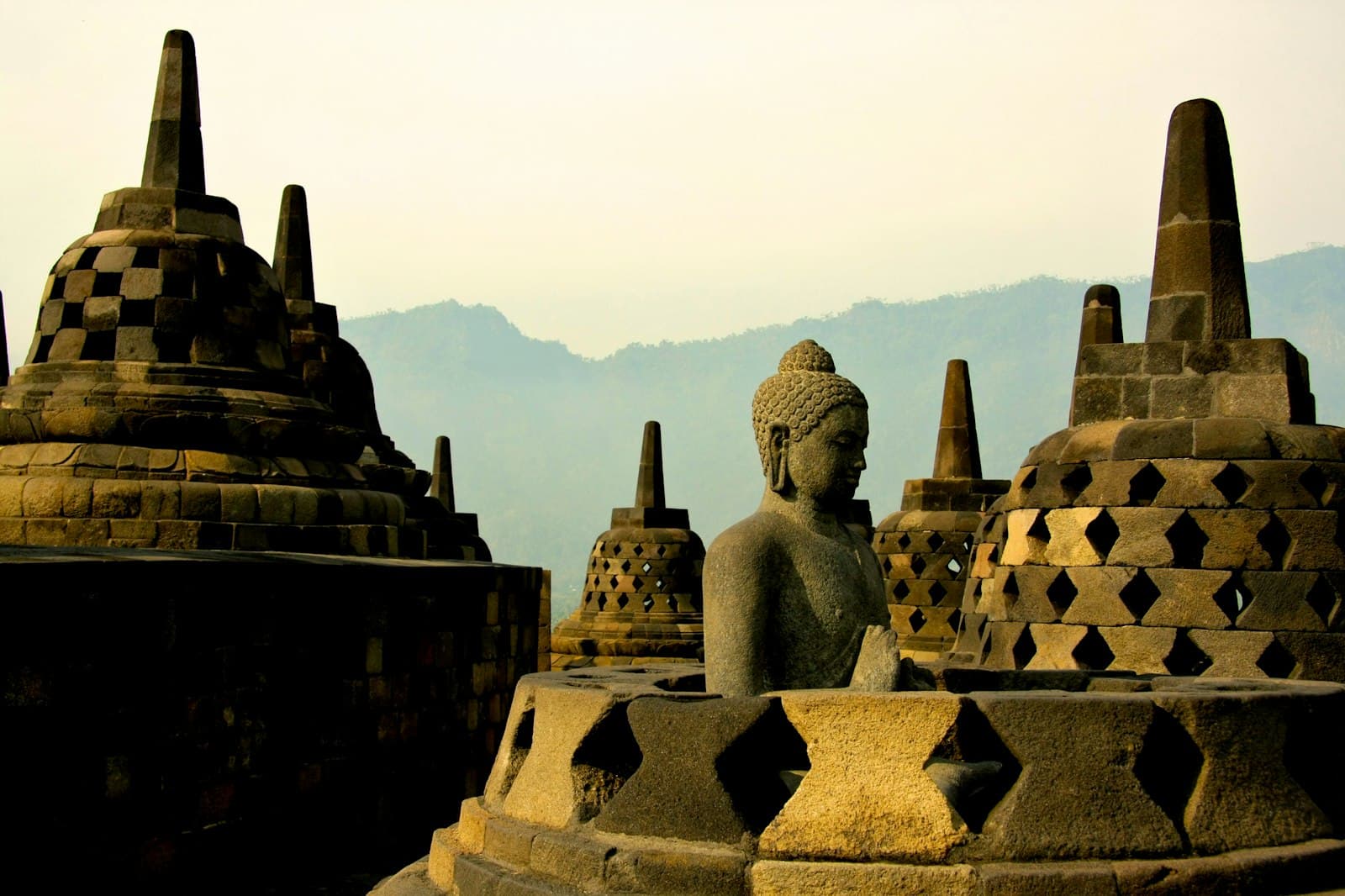 Borobudur — gold buddha statue on top of white and brown concrete building during daytime