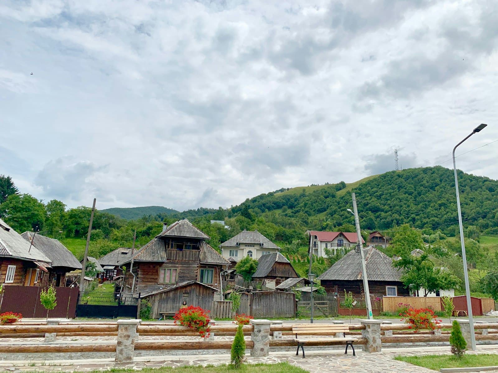 Botiza — a row of wooden buildings sitting on top of a lush green hillside