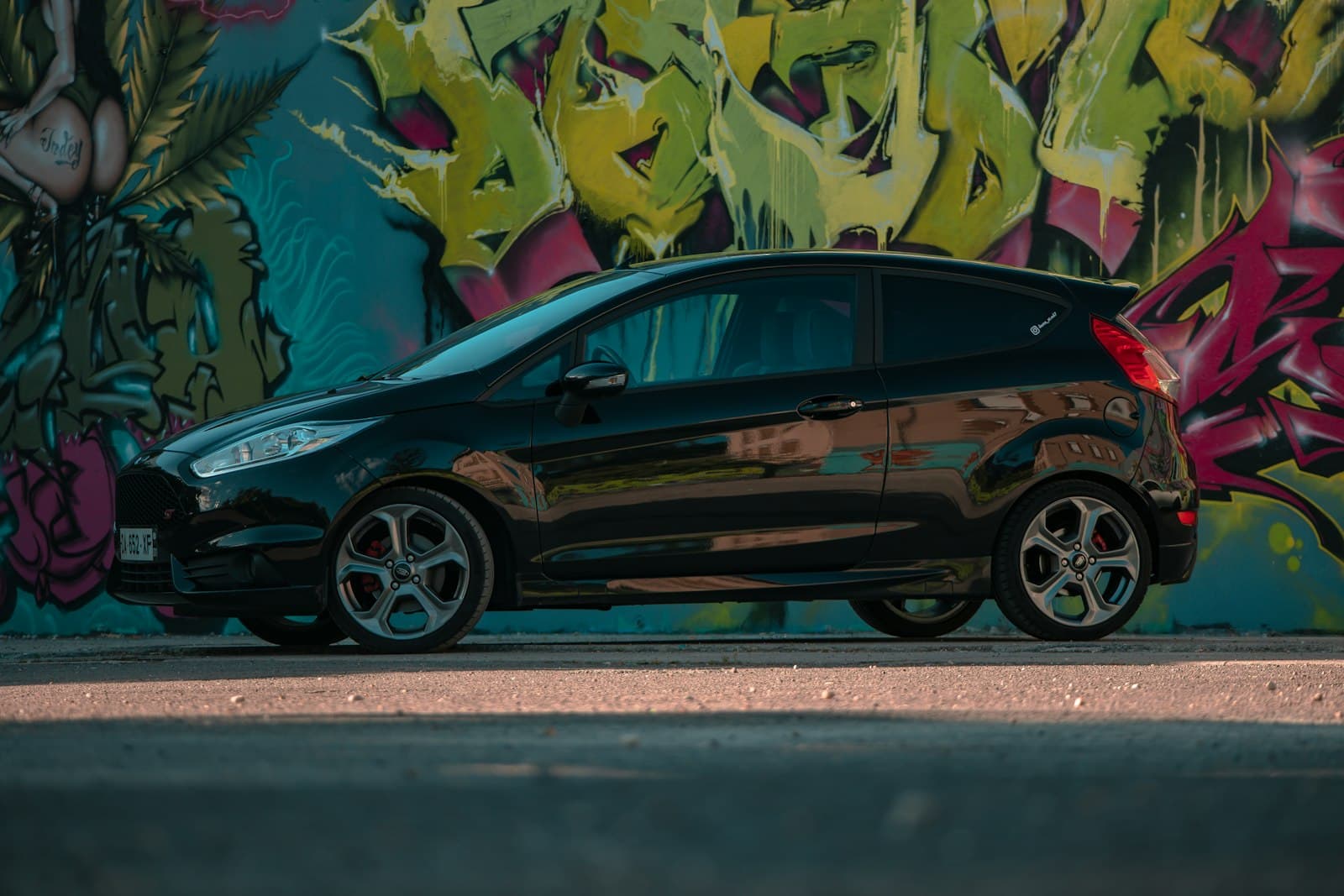 Bourg-en-Bresse — a black car parked in front of a graffiti covered wall