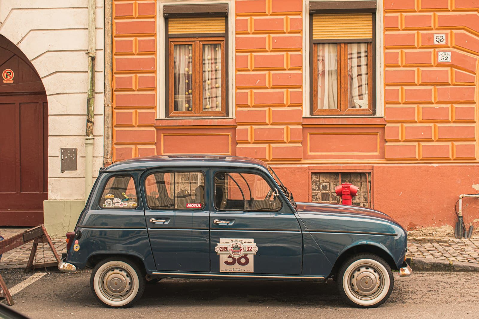 Brașov — a small blue car parked in front of a building