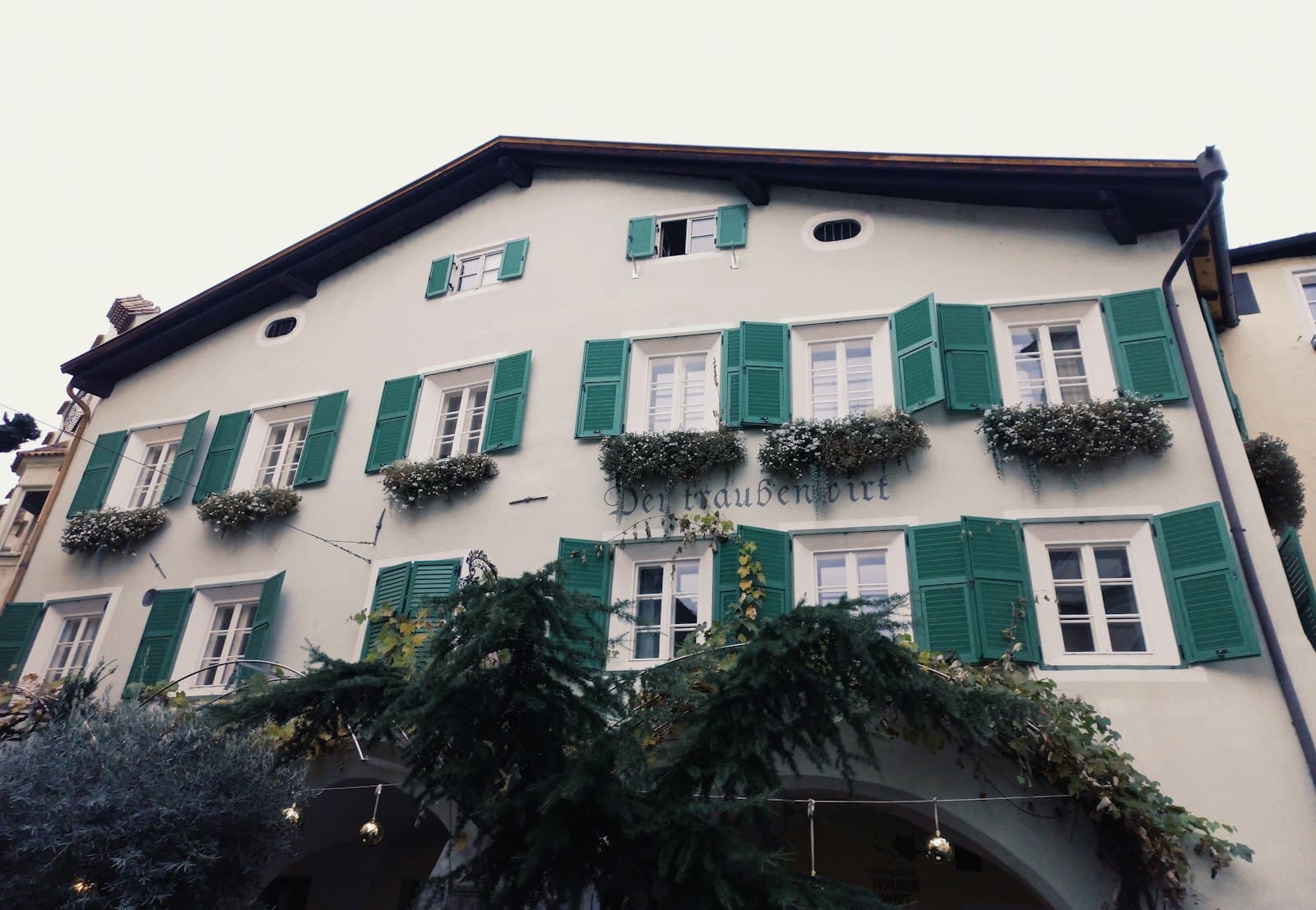 Bressanone — a white building with green shutters and windows