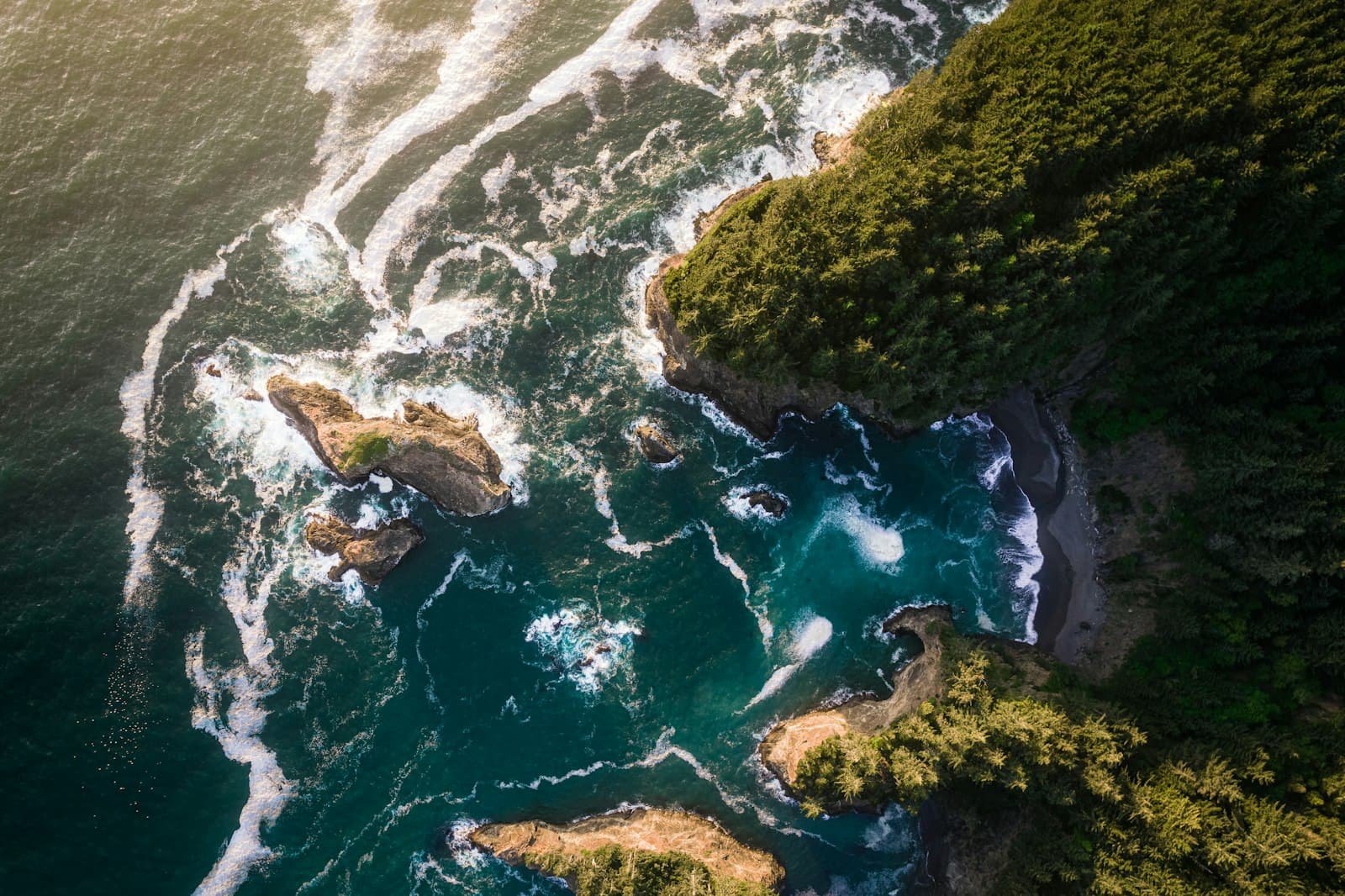 Brookings — aerial view of green and brown rocky mountain beside body of water during daytime