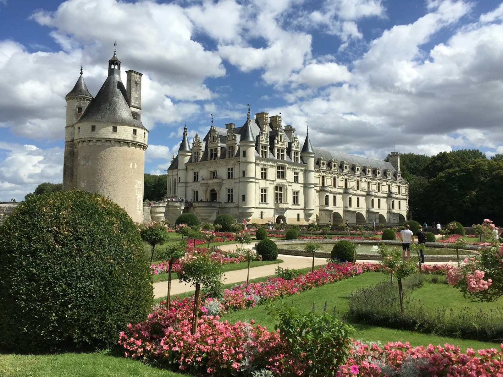 Brousse-le-Château — a large white castle with a garden in front of it with Château de Chenonceau in the background