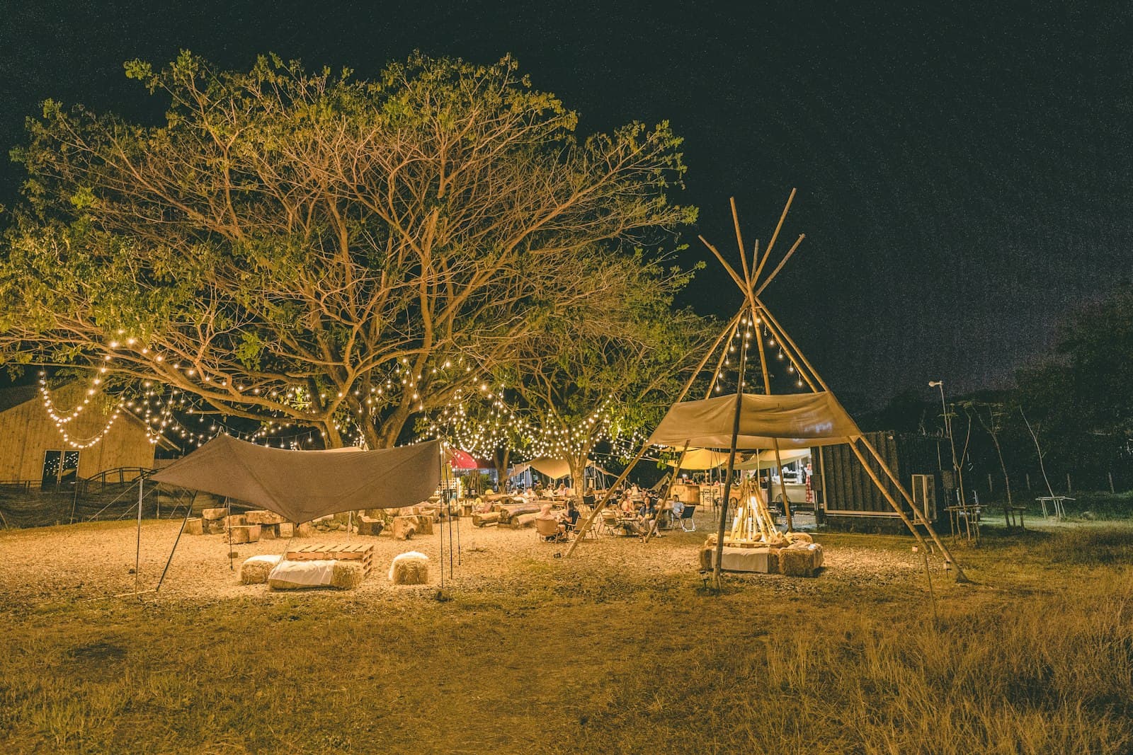 Buriram — a group of people sitting around a tent at night