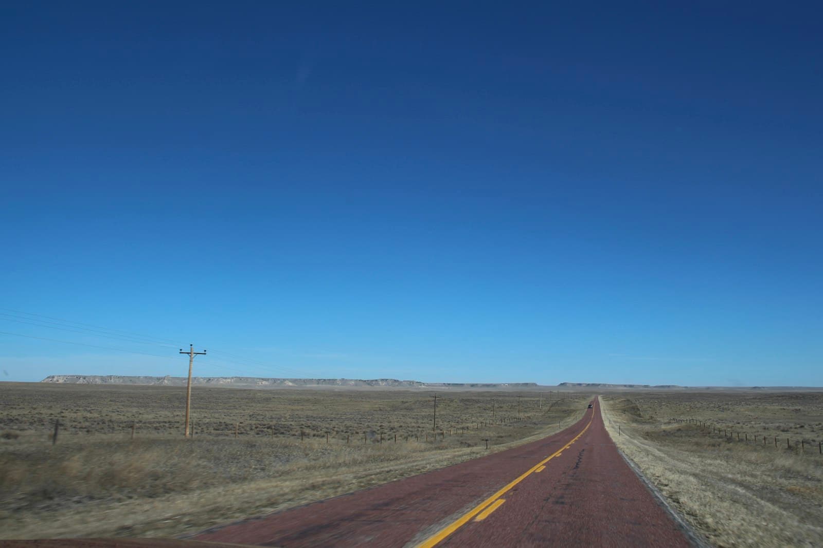 Butte — gray asphalt road under blue sky during daytime