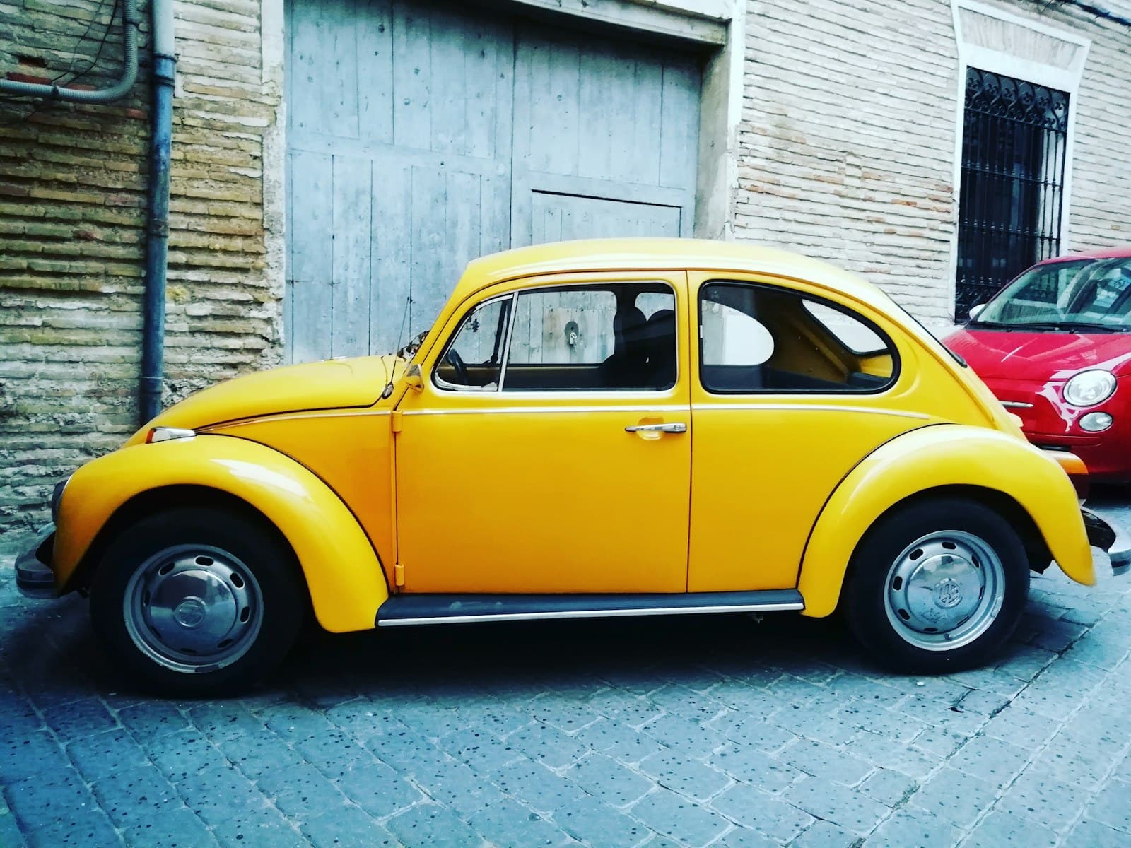 Caravaca de la Cruz — yellow Volkswagen beetle parked near building