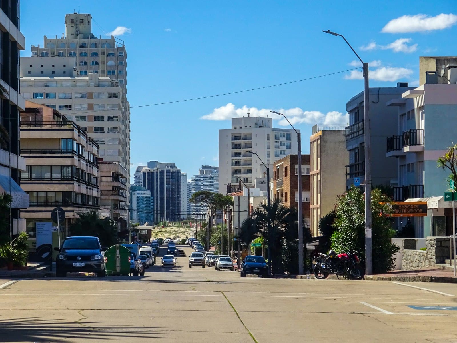 Carmelo — Cars driving on a city street with tall buildings.