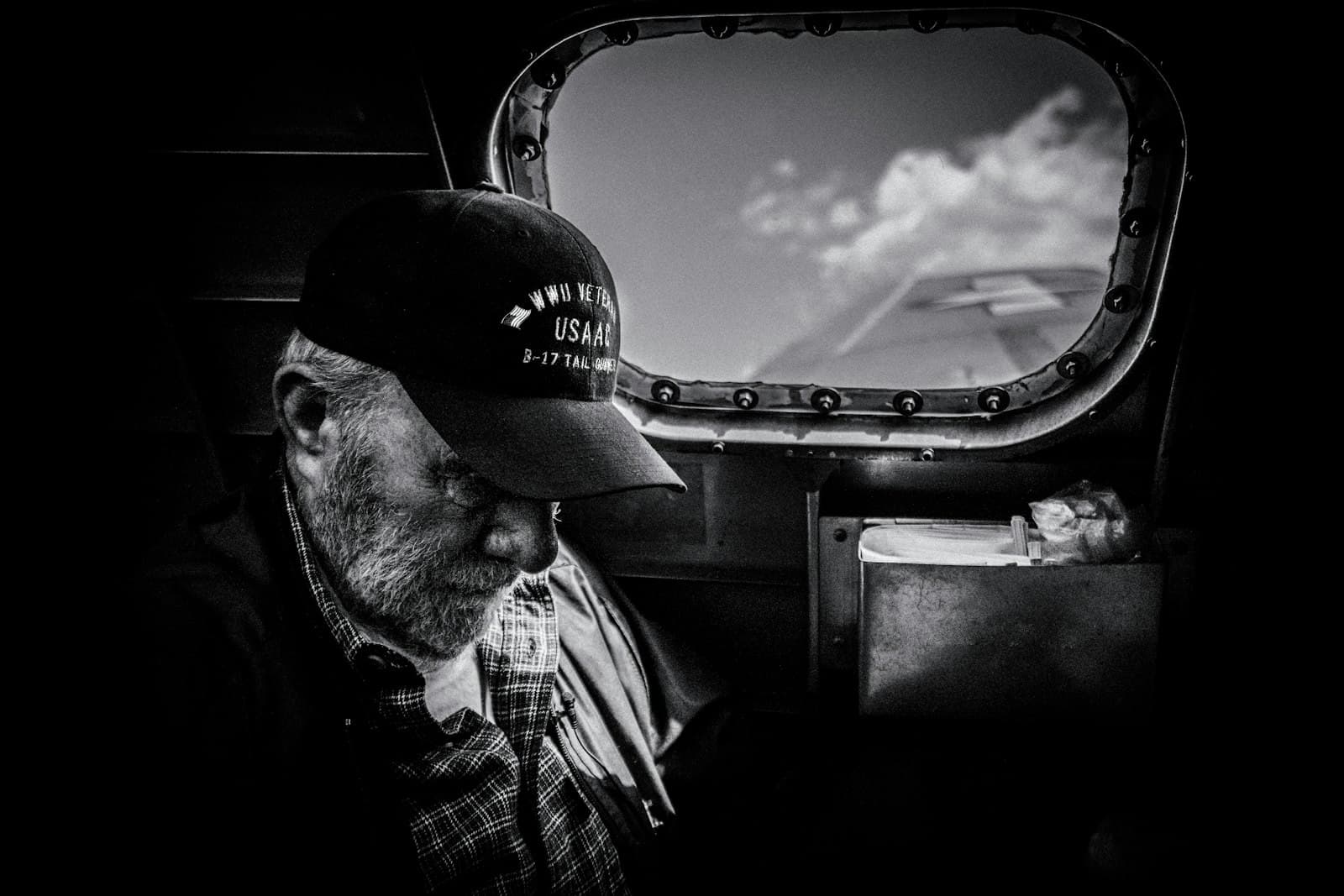 Carson City — grayscale photo of man in plaid shirt and cap looking at the sky