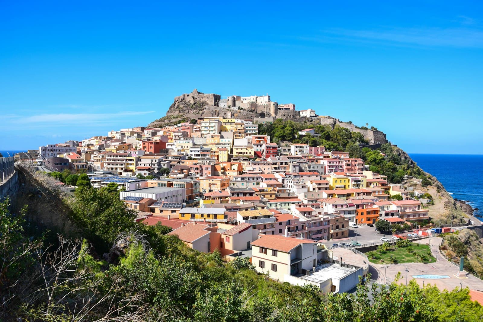 Castelsardo — white and brown concrete houses near green trees under blue sky during daytime