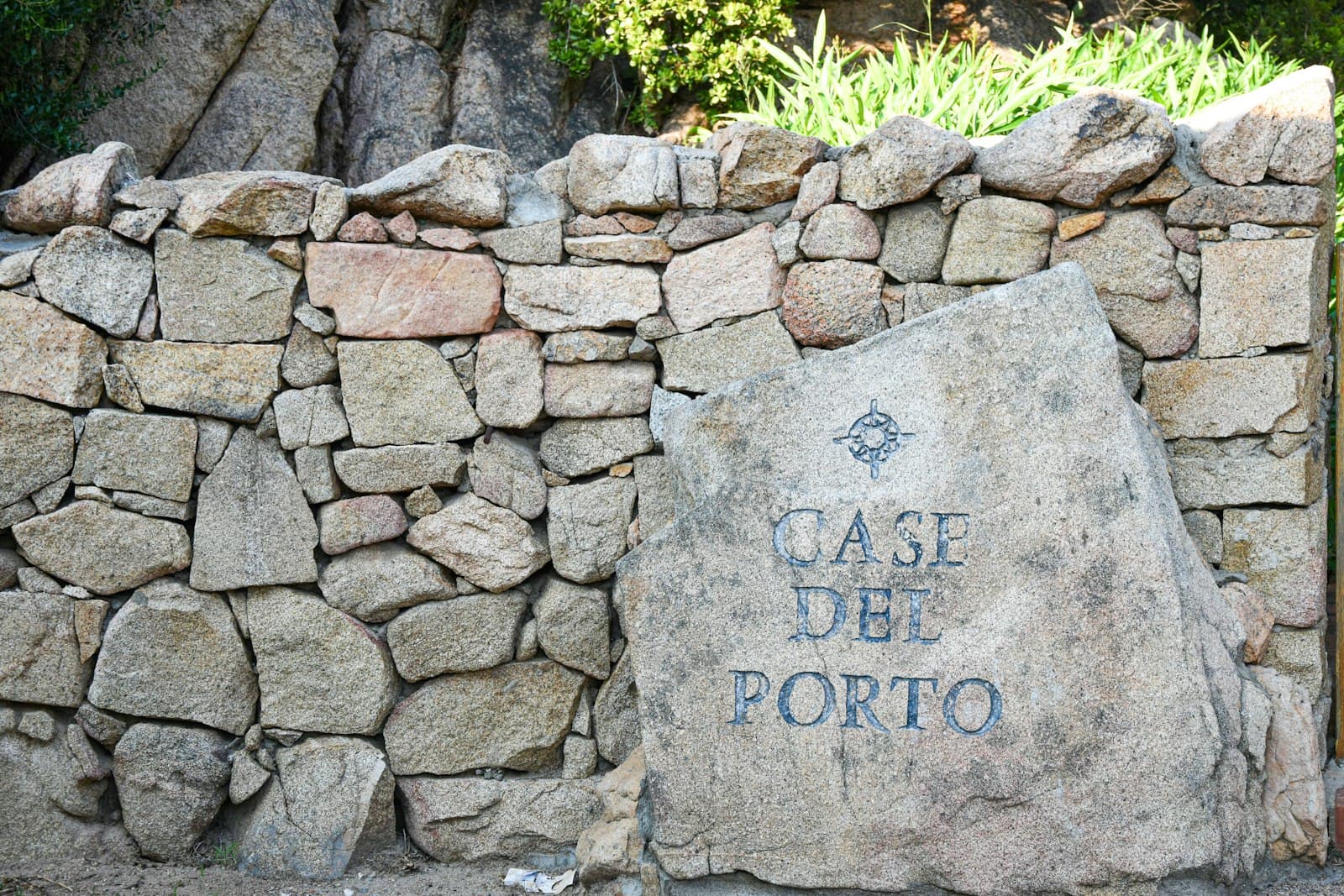Cervo — a stone wall with a sign on it