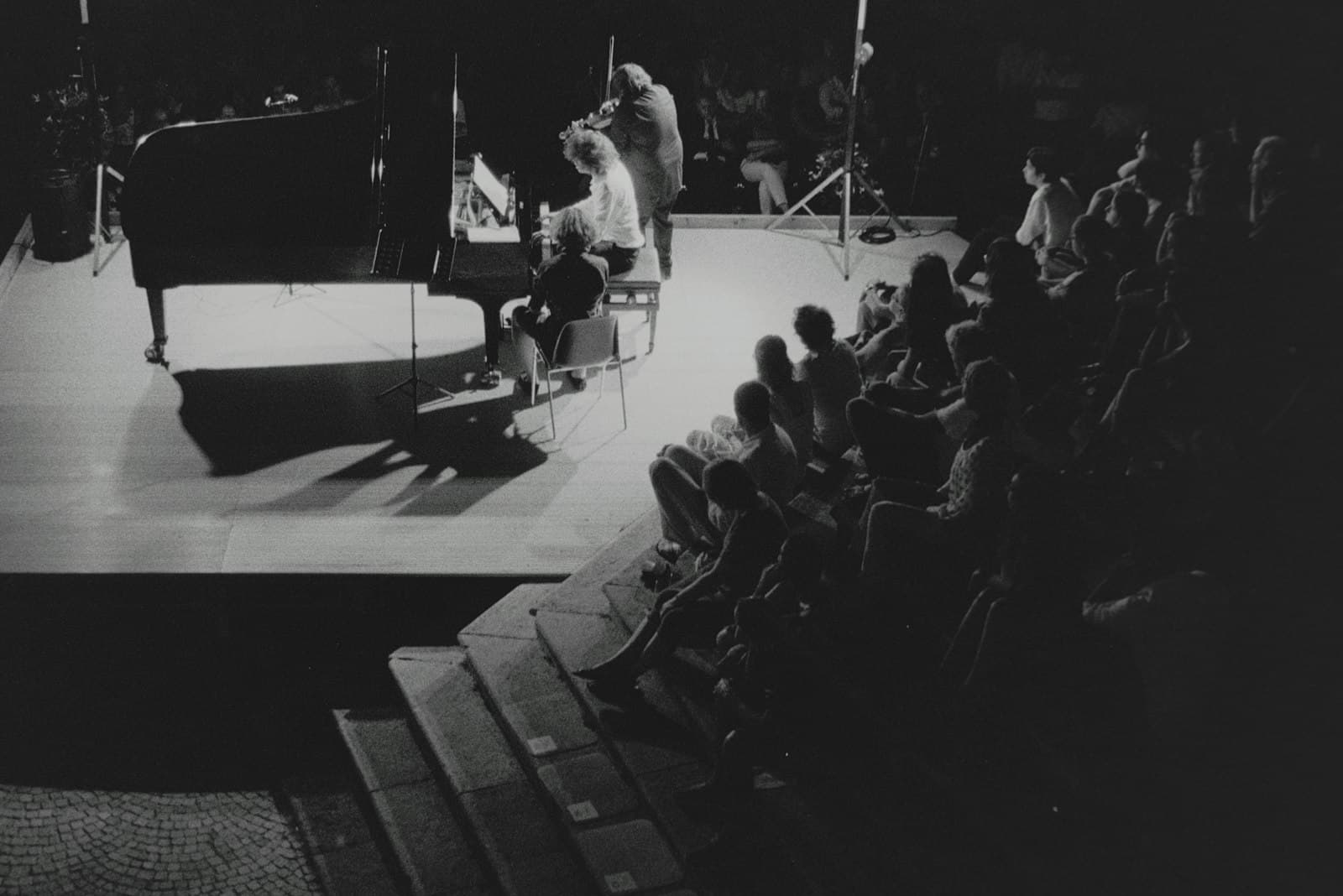 Cervo — a black and white photo of a man playing a piano