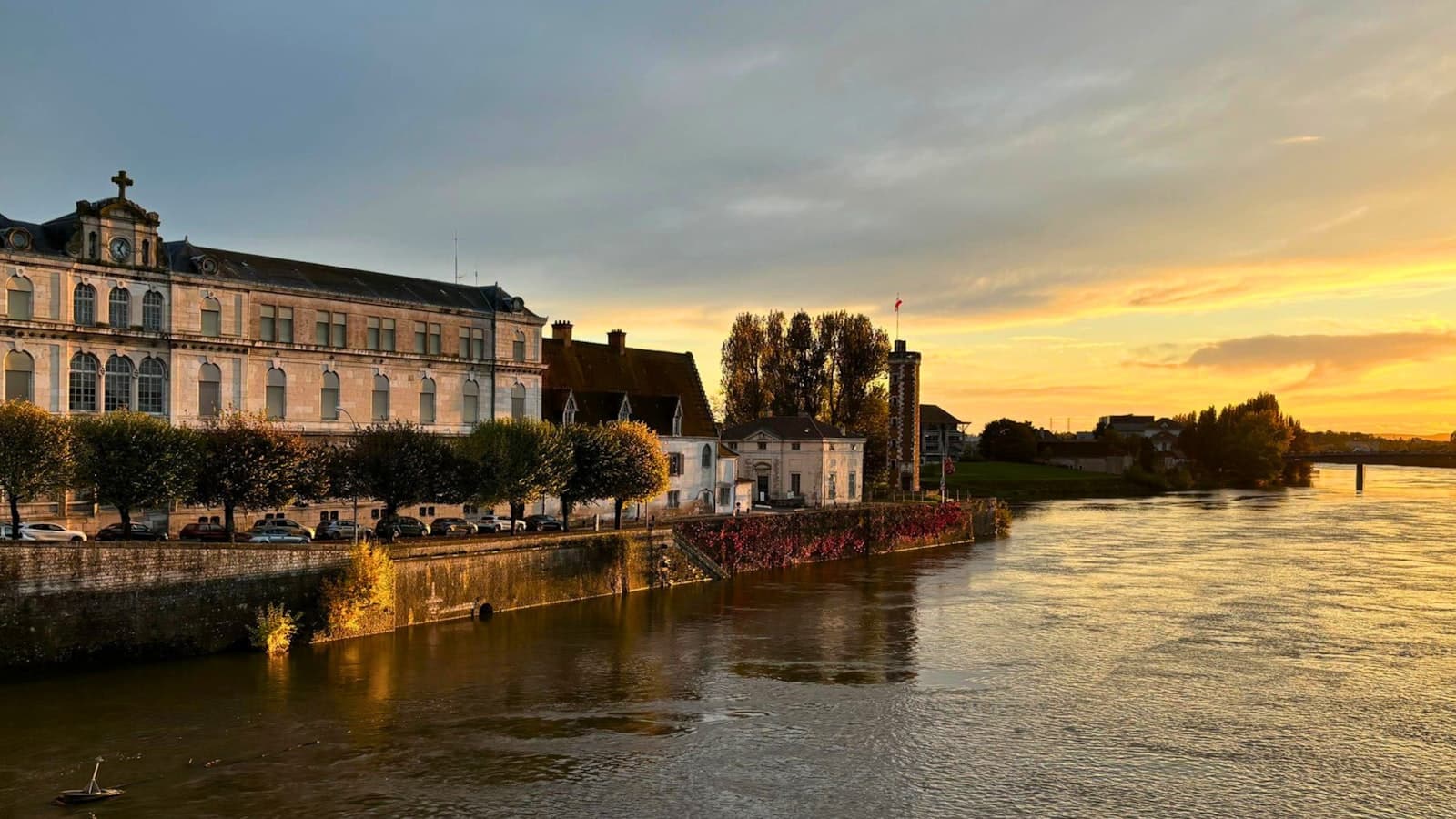 Chalon-sur-Saône — A river running through a city next to a tall building