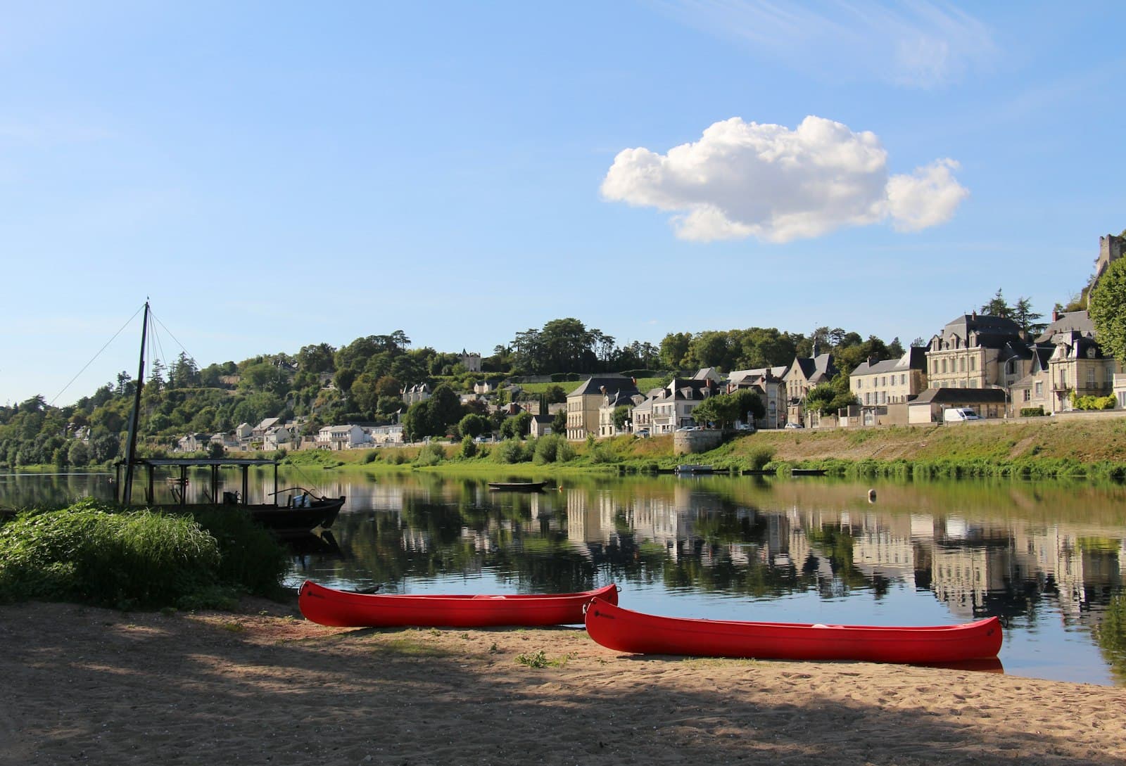 Chinon — red boat on river near green trees during daytime