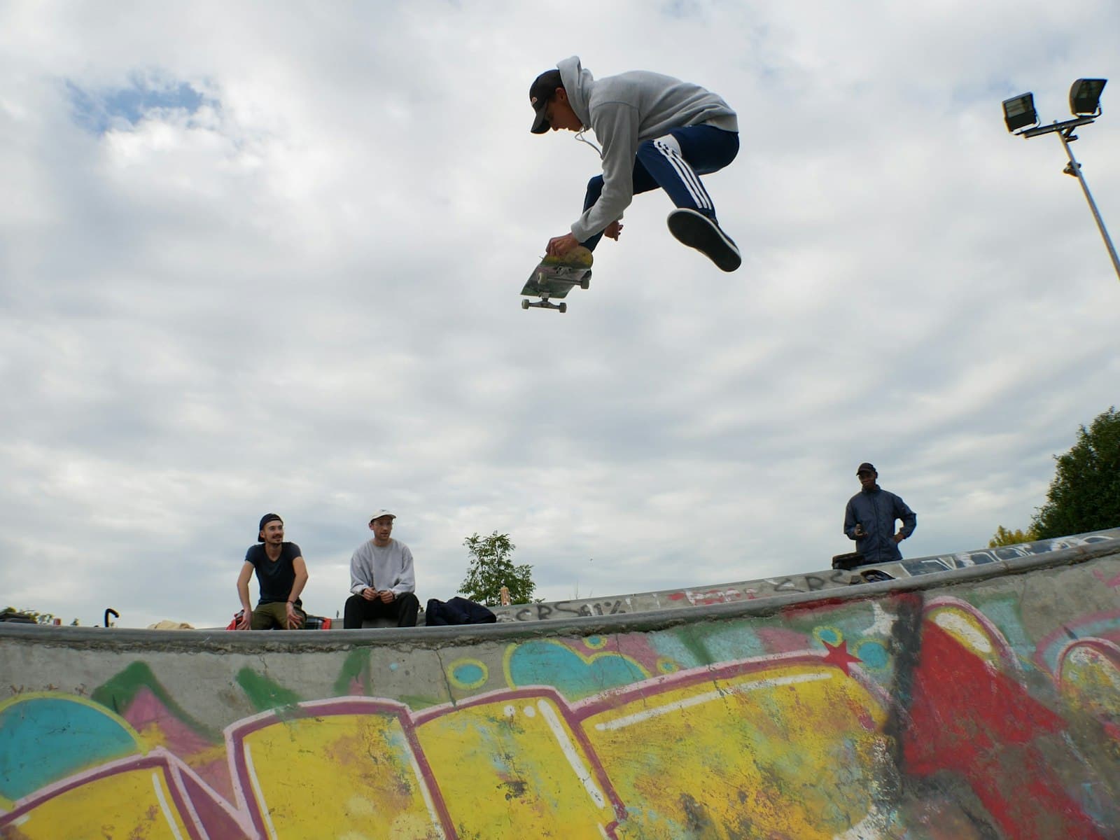 Cholet — man on air playing skateboard above skateboard ramp at daytime