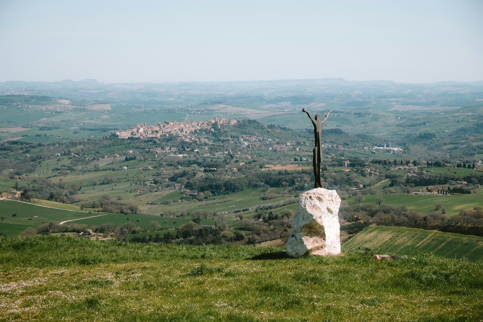 Cingoli — Sculpture on a grassy hill overlooking a town