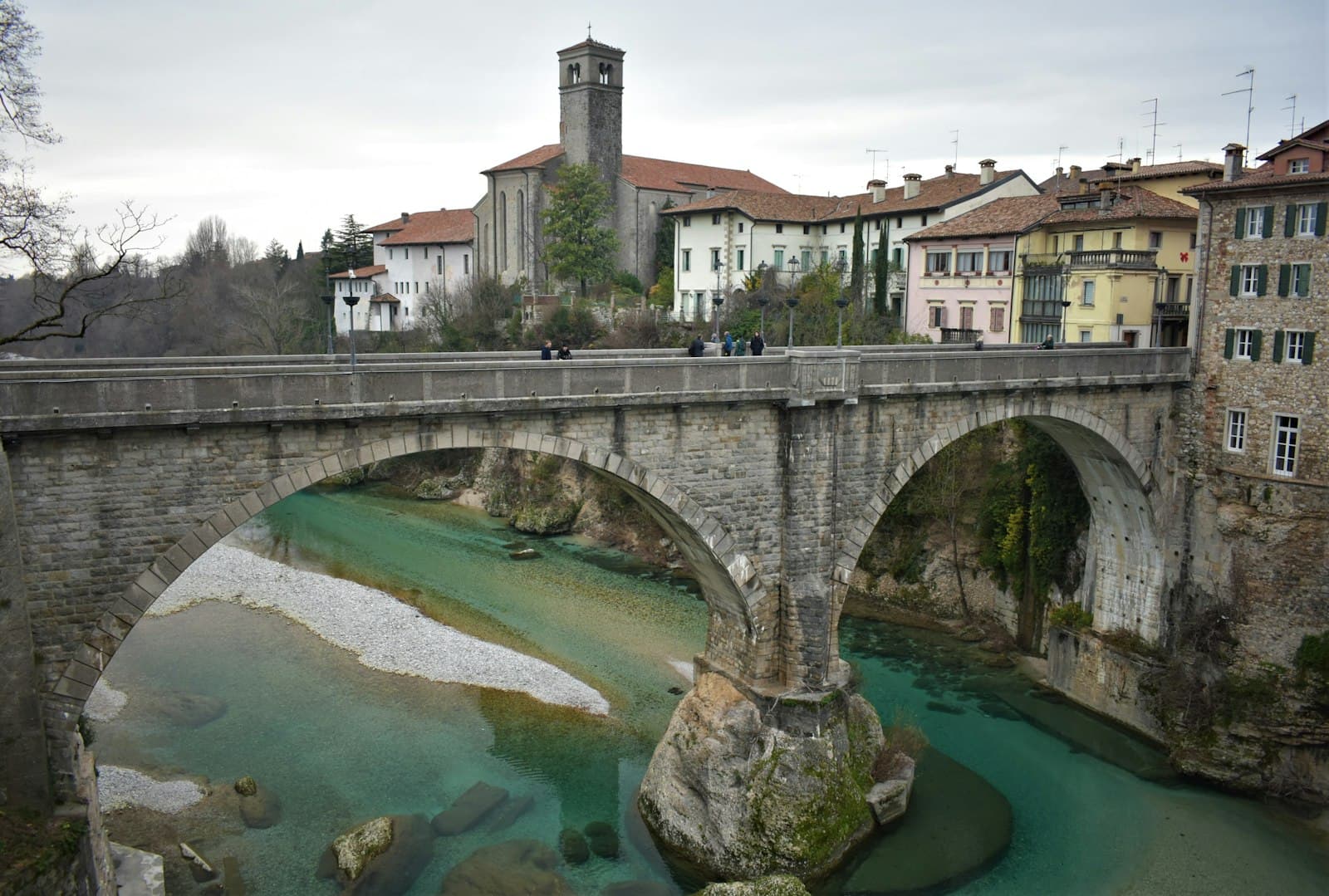 Cividale del Friuli — a stone bridge over a river with buildings in the background