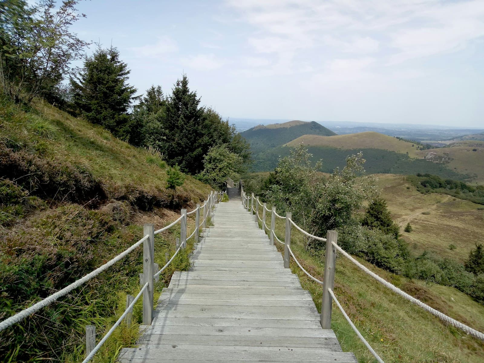 Clermont-Ferrand — brown wooden bridge over green mountains during daytime
