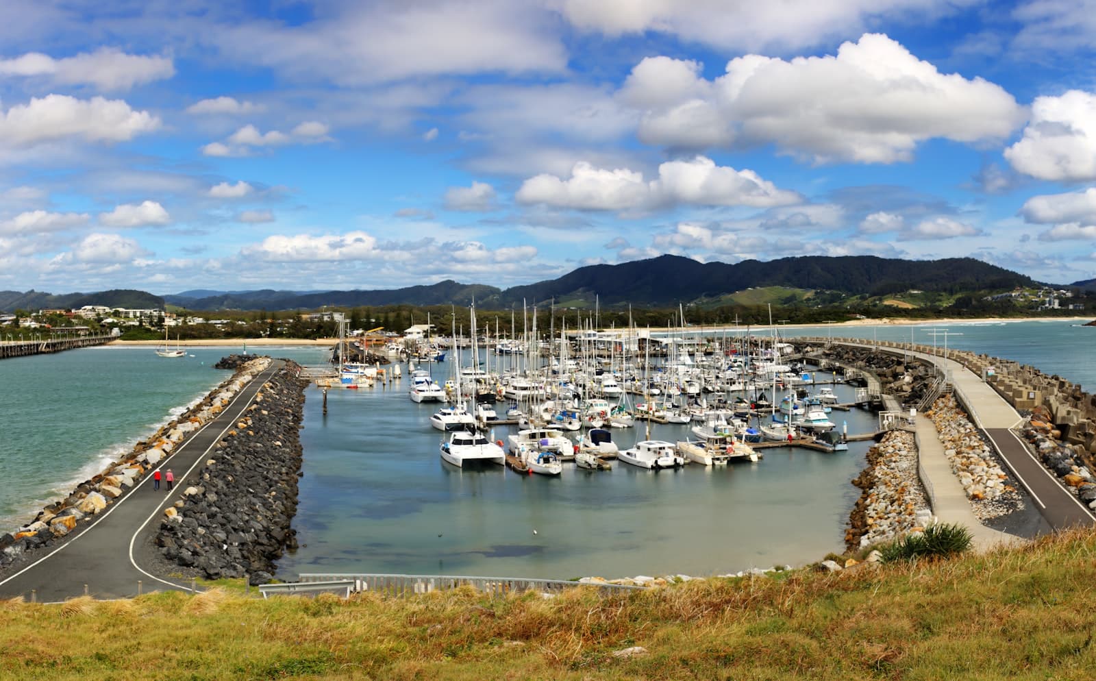 Coffs Harbour — a harbor filled with lots of boats under a cloudy blue sky