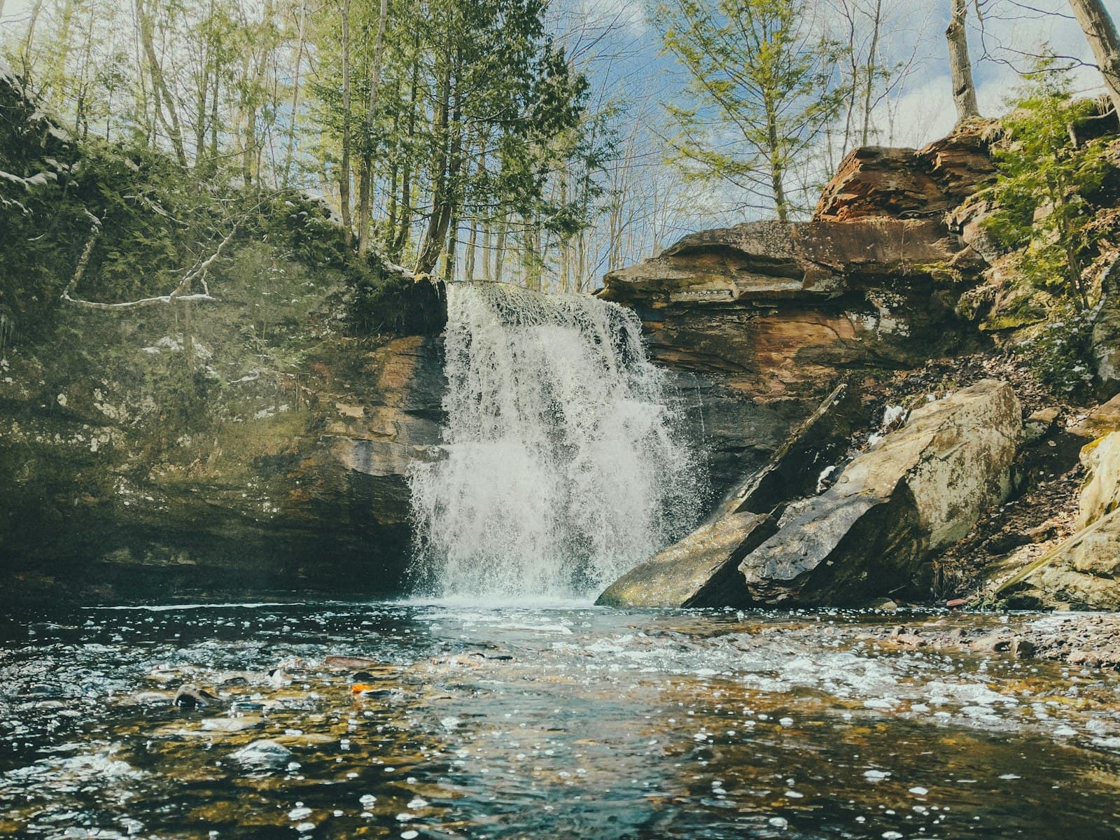 Cold Spring — water falls on brown rocky mountain during daytime