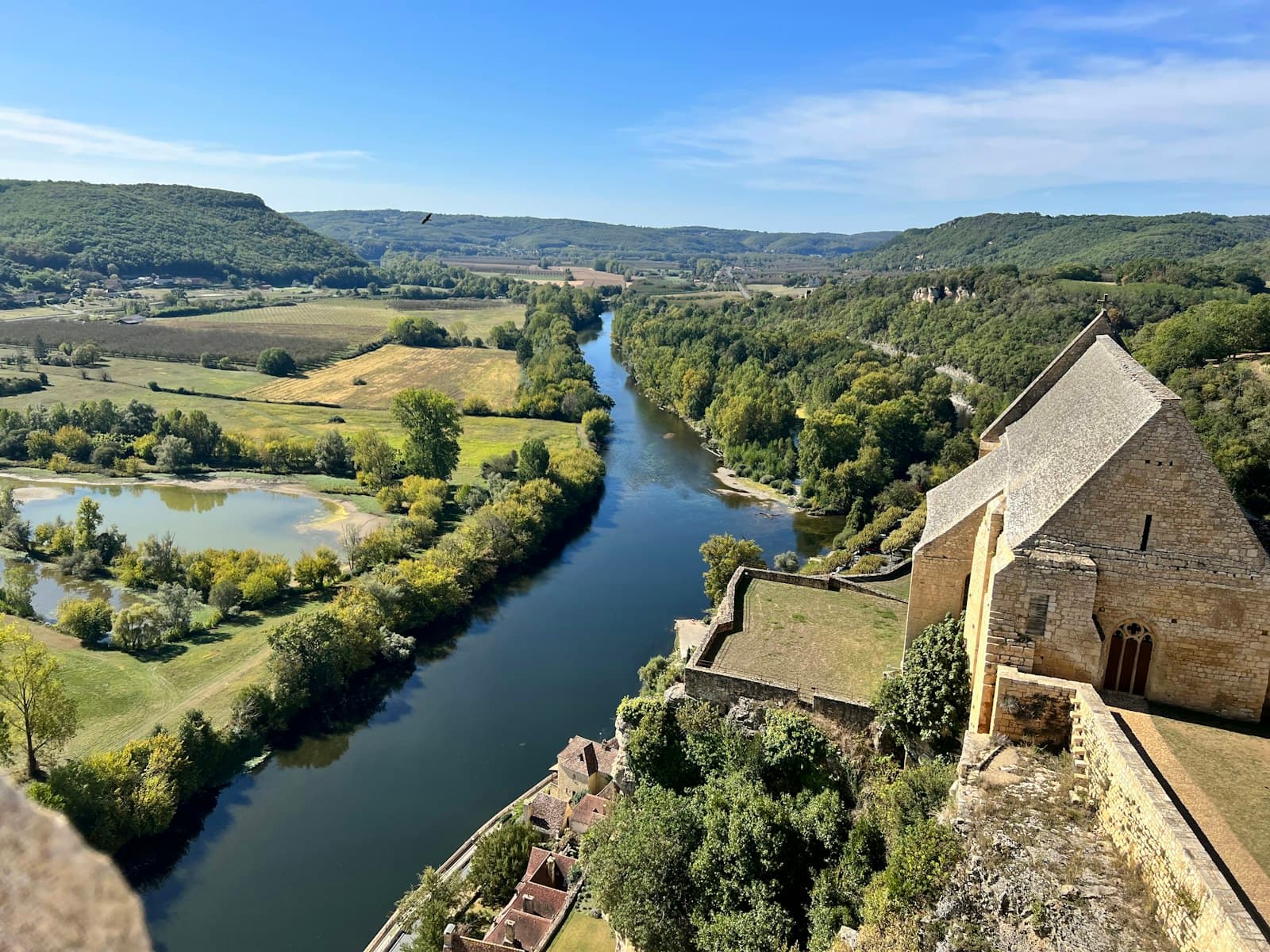 Collonges-la-Rouge — a river running through a lush green countryside
