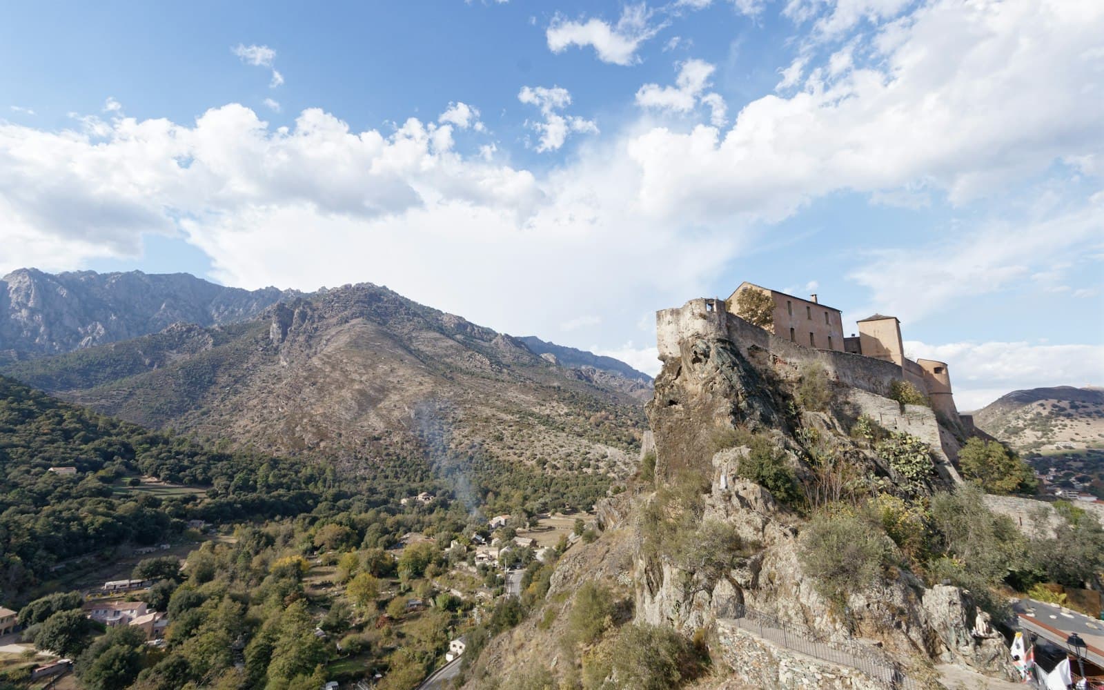 Corte — Historic fortress perched on a rocky mountain under blue sky