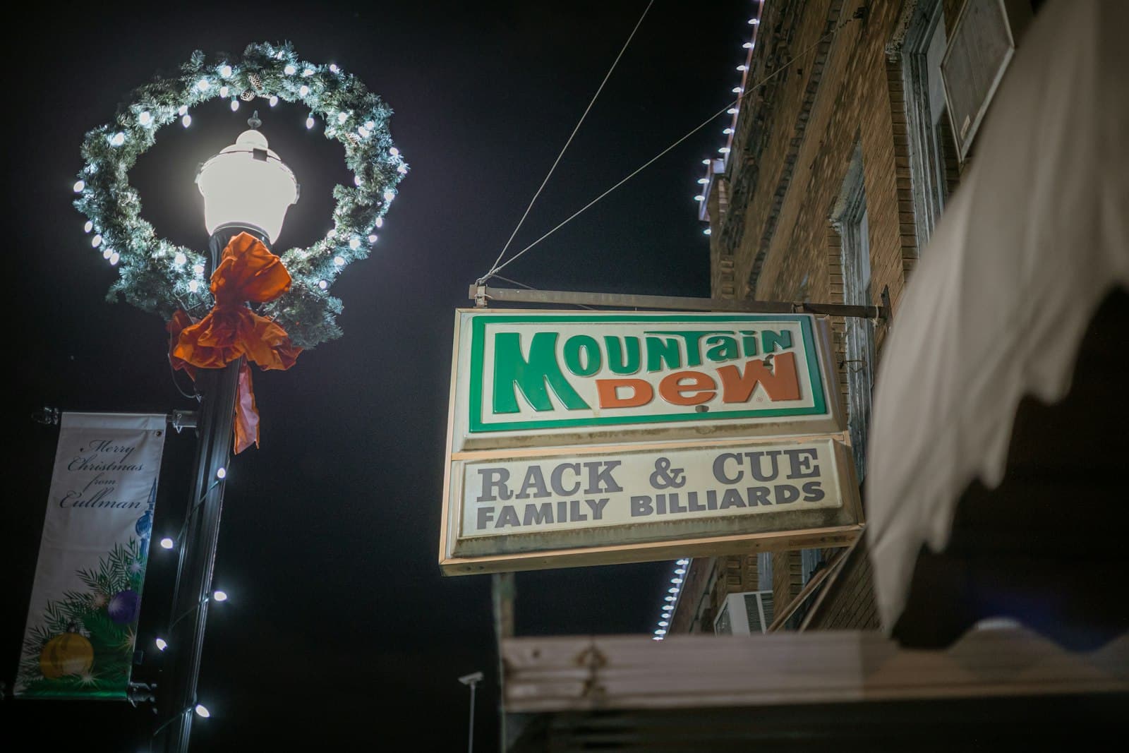 Cullman — a mountain dew sign with a wreath hanging from it's side