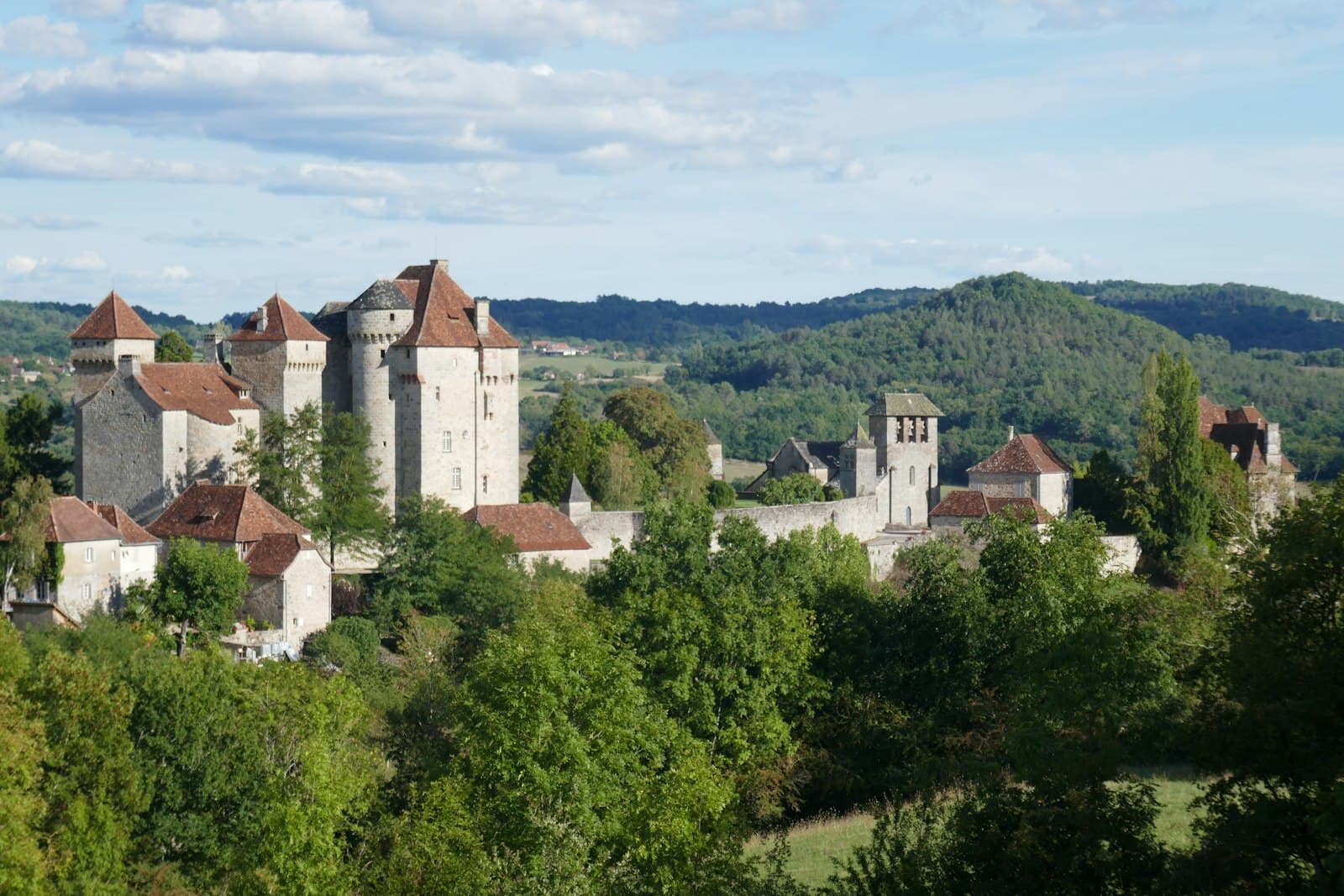 Curemonte — A castle is nestled among lush green trees.