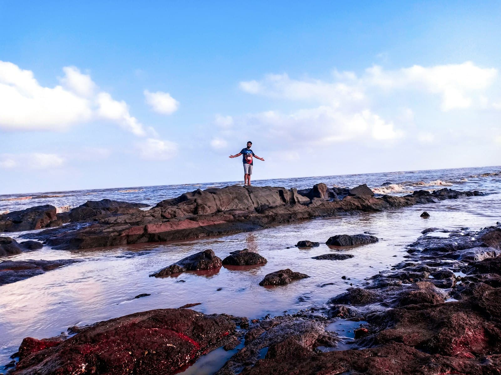 Daman — man standing on rock near body of water
