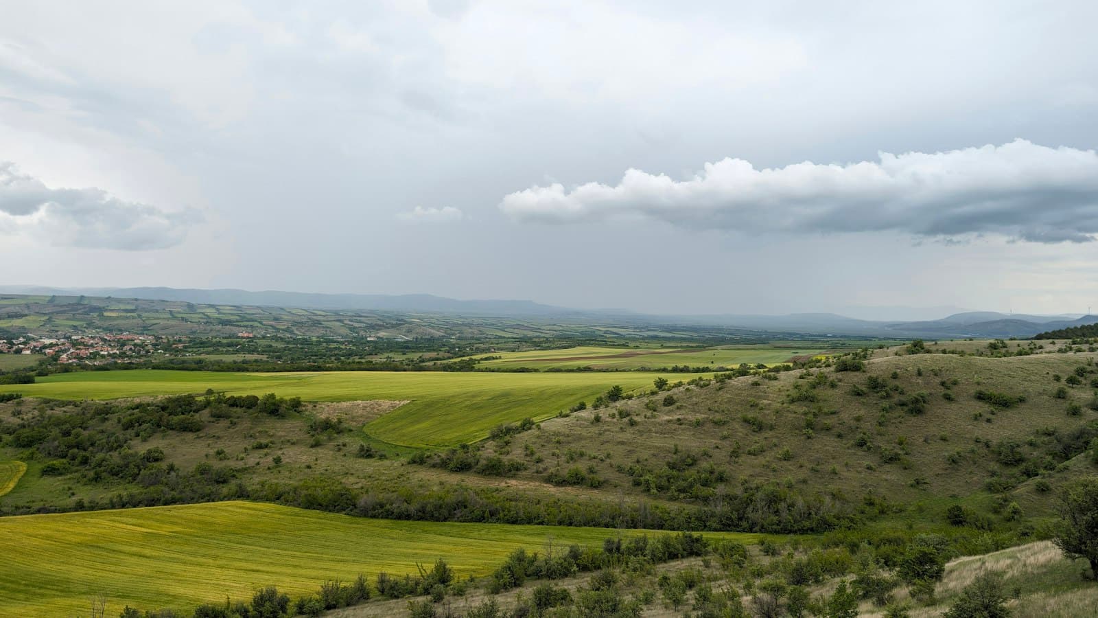 Debar — A view of a green field and a town in the distance