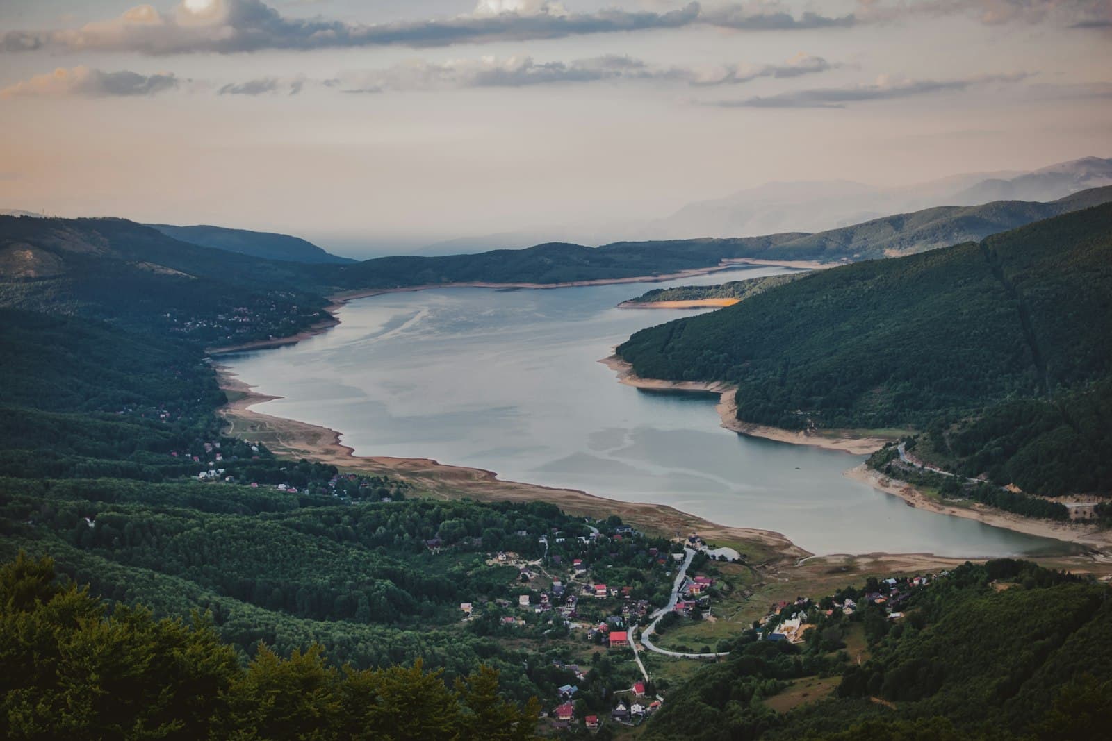 Debar — green trees near body of water under cloudy sky during daytime