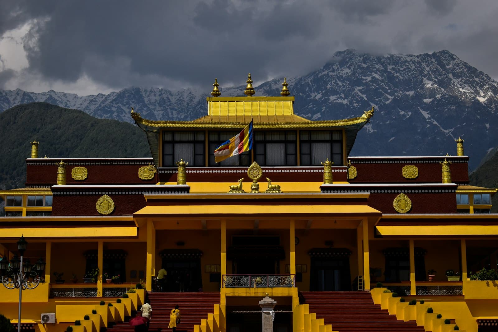 Dharamshala — a yellow and red building with mountains in the background